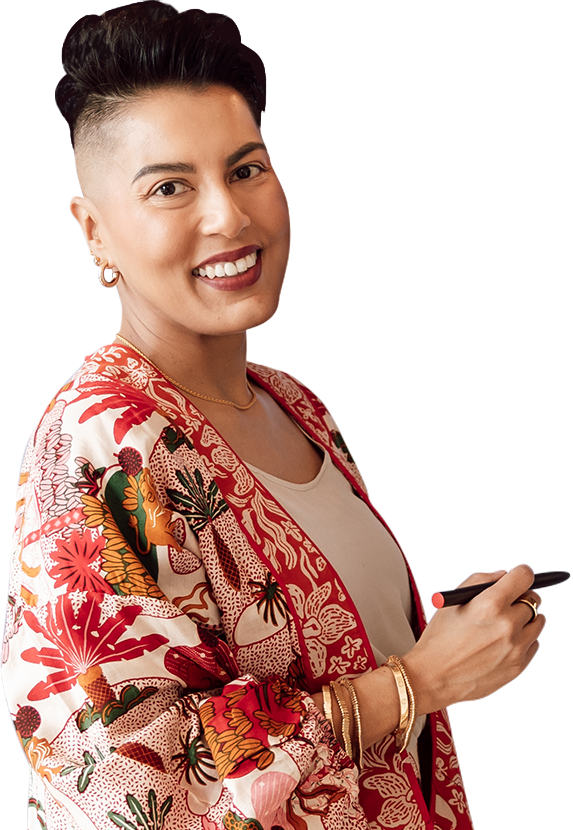 Sharon Pakir wearing a vibrant patterned suit, holding a digital pen in her hand and delivering corporate leadership training