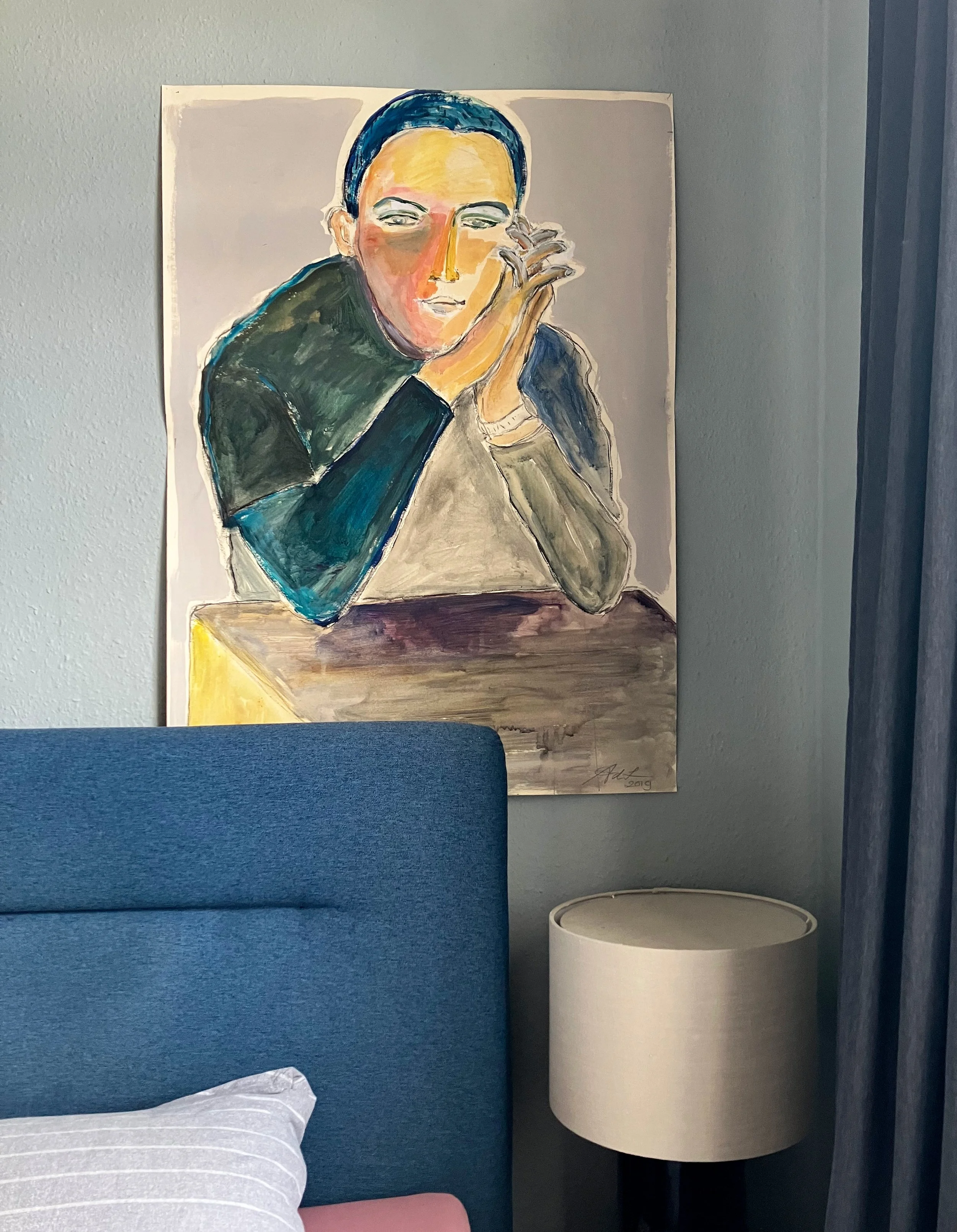 een abstract schilderij door Anna de Leeuw van een vrouw met kort donker haar, die met haar hand haar gezicht aanraakt, in zachte verfkleuren, hangt aan een grijze muur.