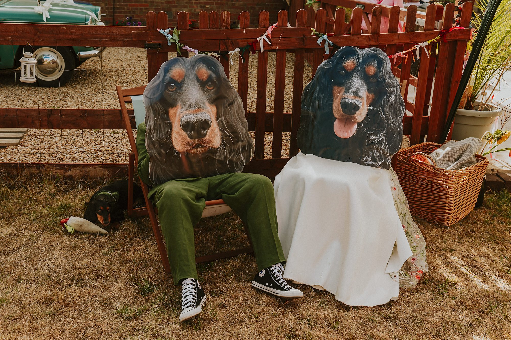 A funny wedding portrait of a Bride & Groom wearing giant masks of their dogs face in this Lincolnshire garden wedding.