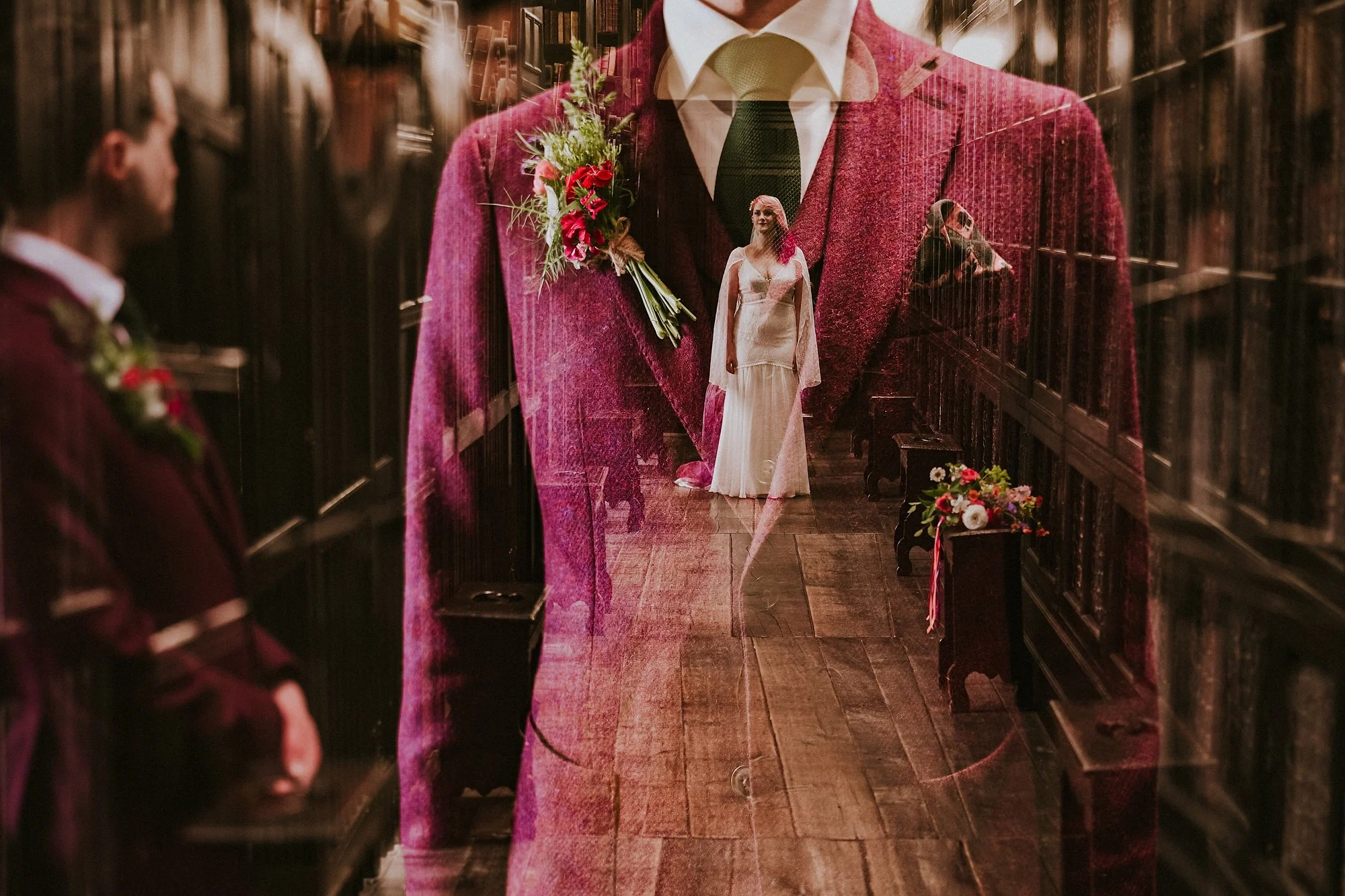 A double exposure of a Bride & groom inside Chetham's library.  The groom wears a dark pink suit and the bride has pink hair in this creative portrait.