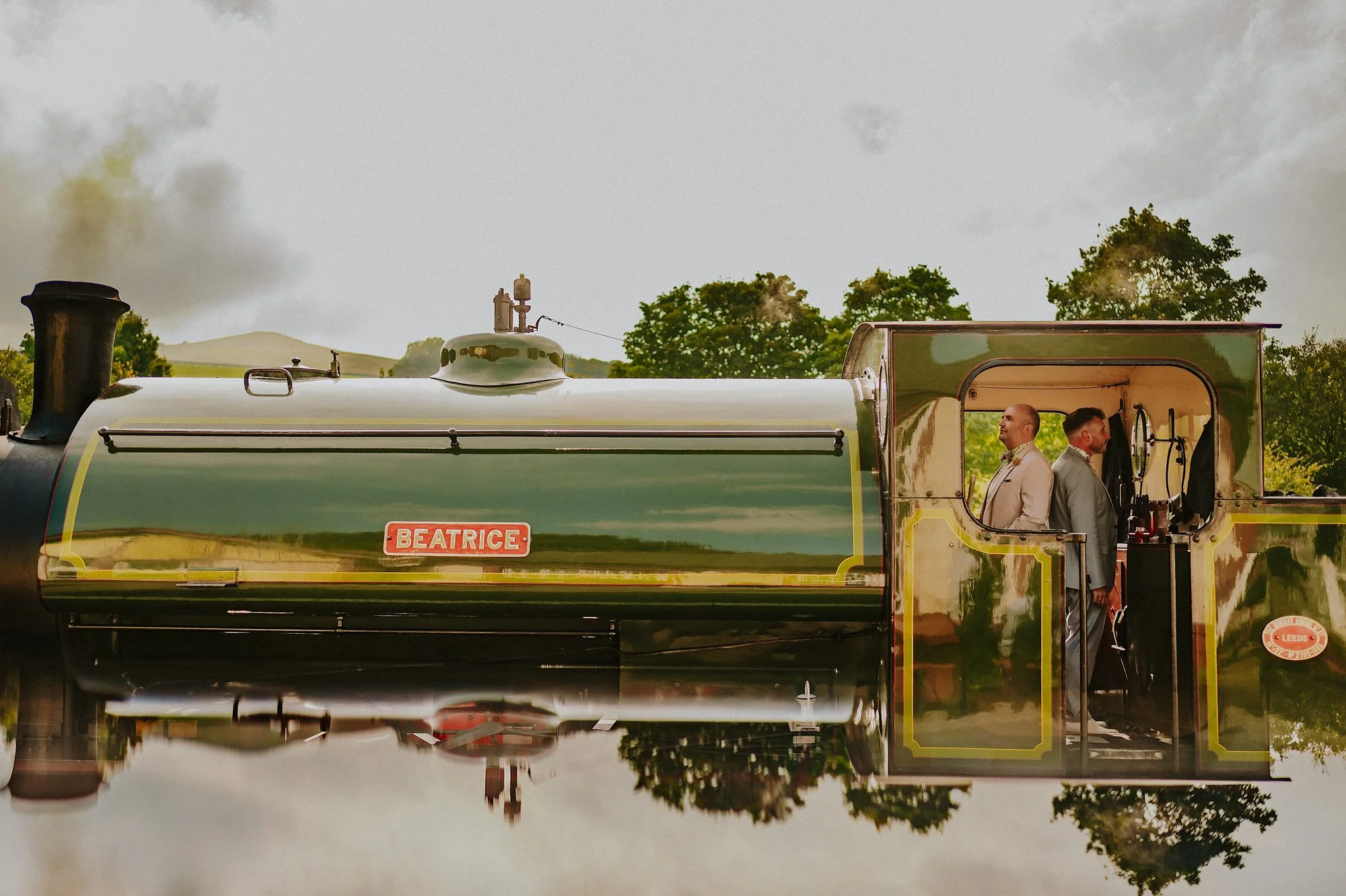 A reflection of a train engine at Embsay Bolton Abbey  steam railway. The grooms stand back to back in the engine room. Symmetry and surrealism on a train.