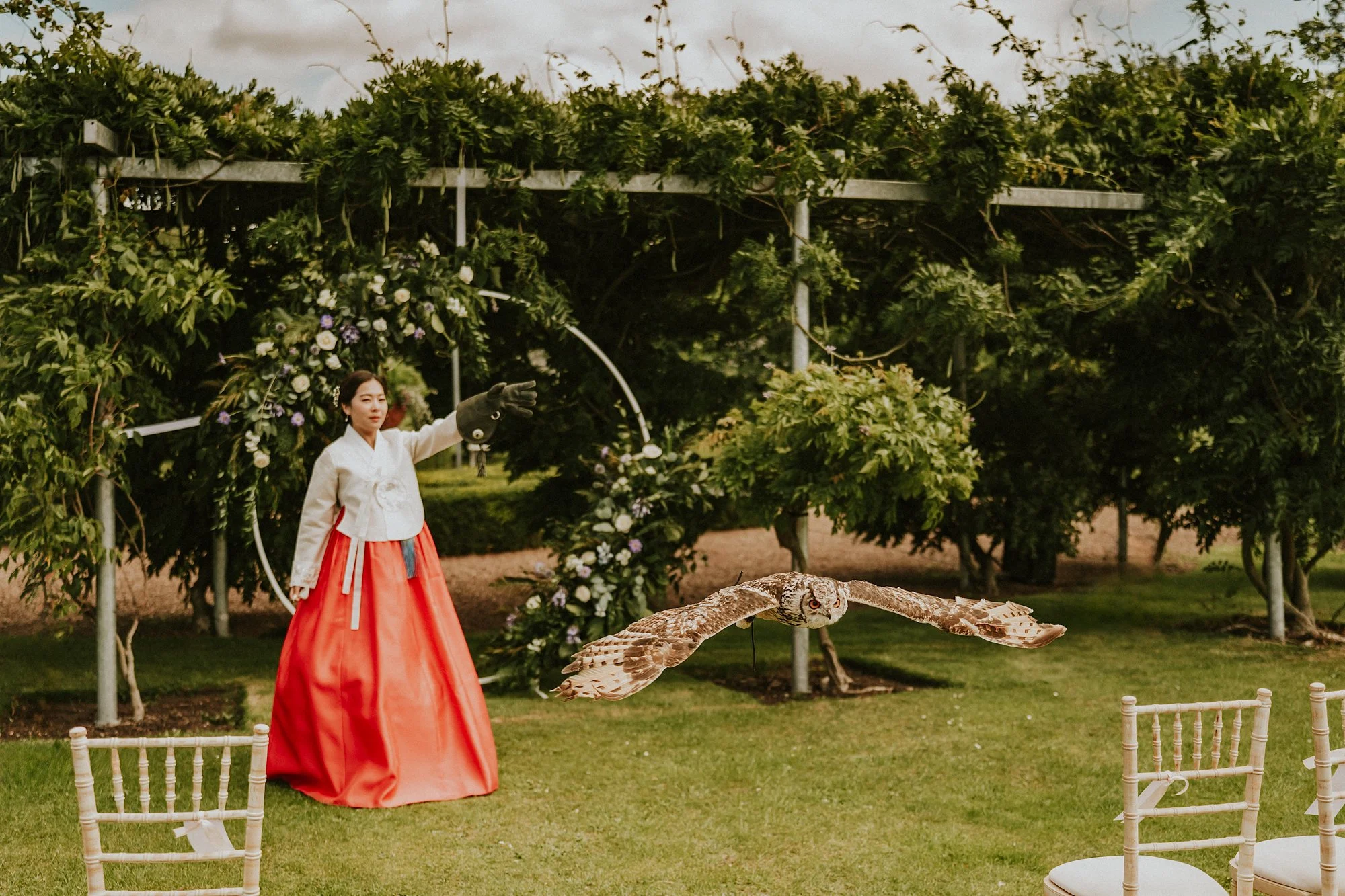 A Korean bride in traditional dress does owl training in the grounds of Winton Castle. The epic wing span of the owl in flight is stunning.