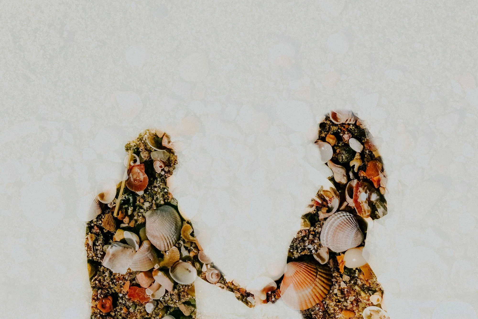 A Lincolnshire coast maternity photoshoot. This photo shows a double exposure of a pregnant couple with seashells.