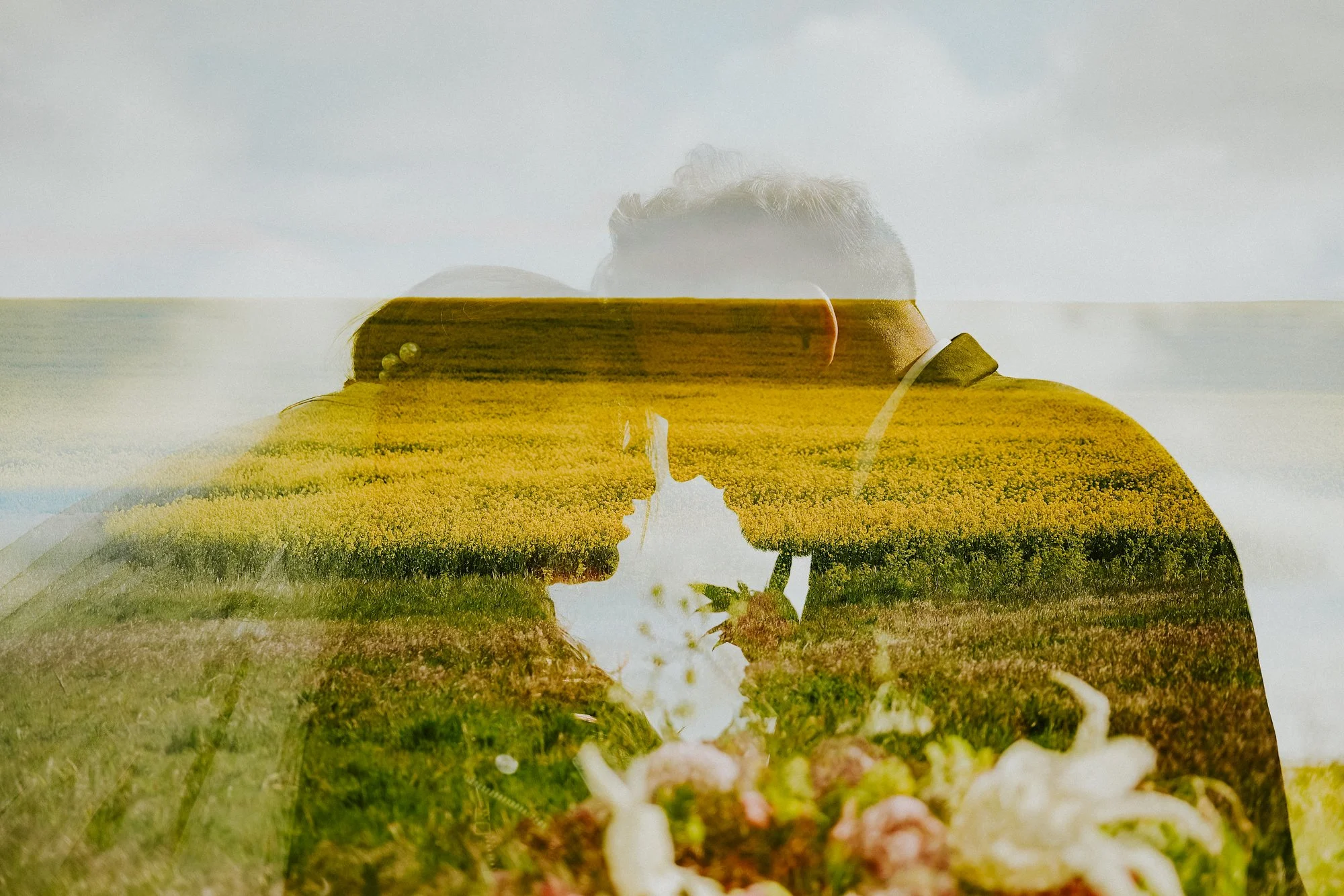 A double exposure bride and groom portrait amidst the yellow flowers surrounding Titchwell Manor.