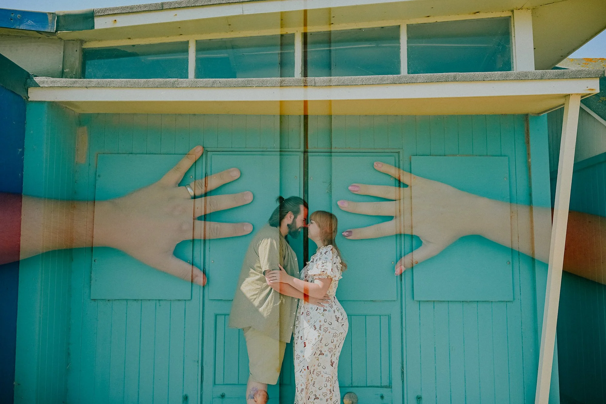 Cool maternity photography on the Lincolnshire coast. A double exposure of hands and a couple kiss.