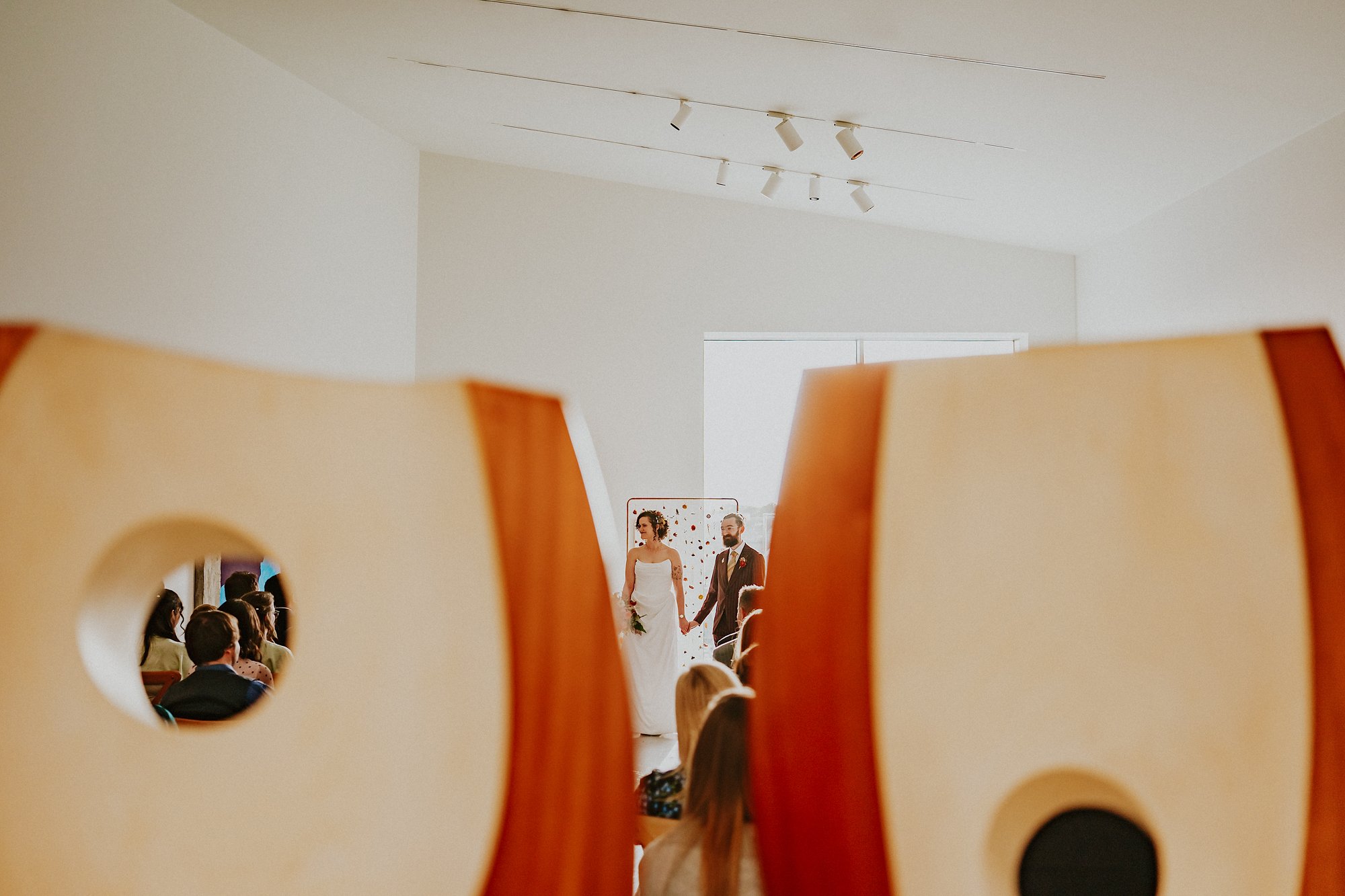 A wedding ceremony in full swing at the Hepworth in Wakefield. The Bride and Groom stand in between two sculptures while saying their vows.