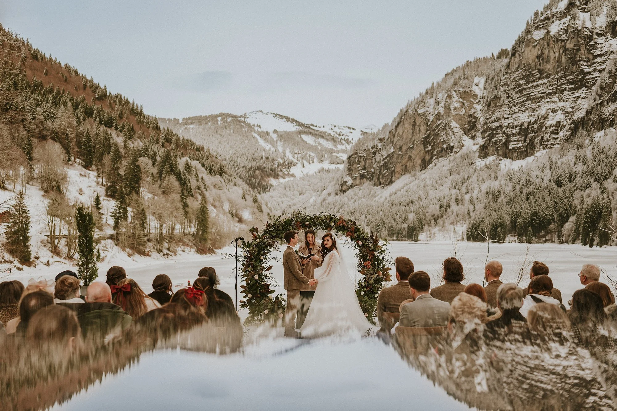 A flower backdrop, the French alps & the frozen Lac Montriond provide the epic backdrop for this French destination wedding ceremony.