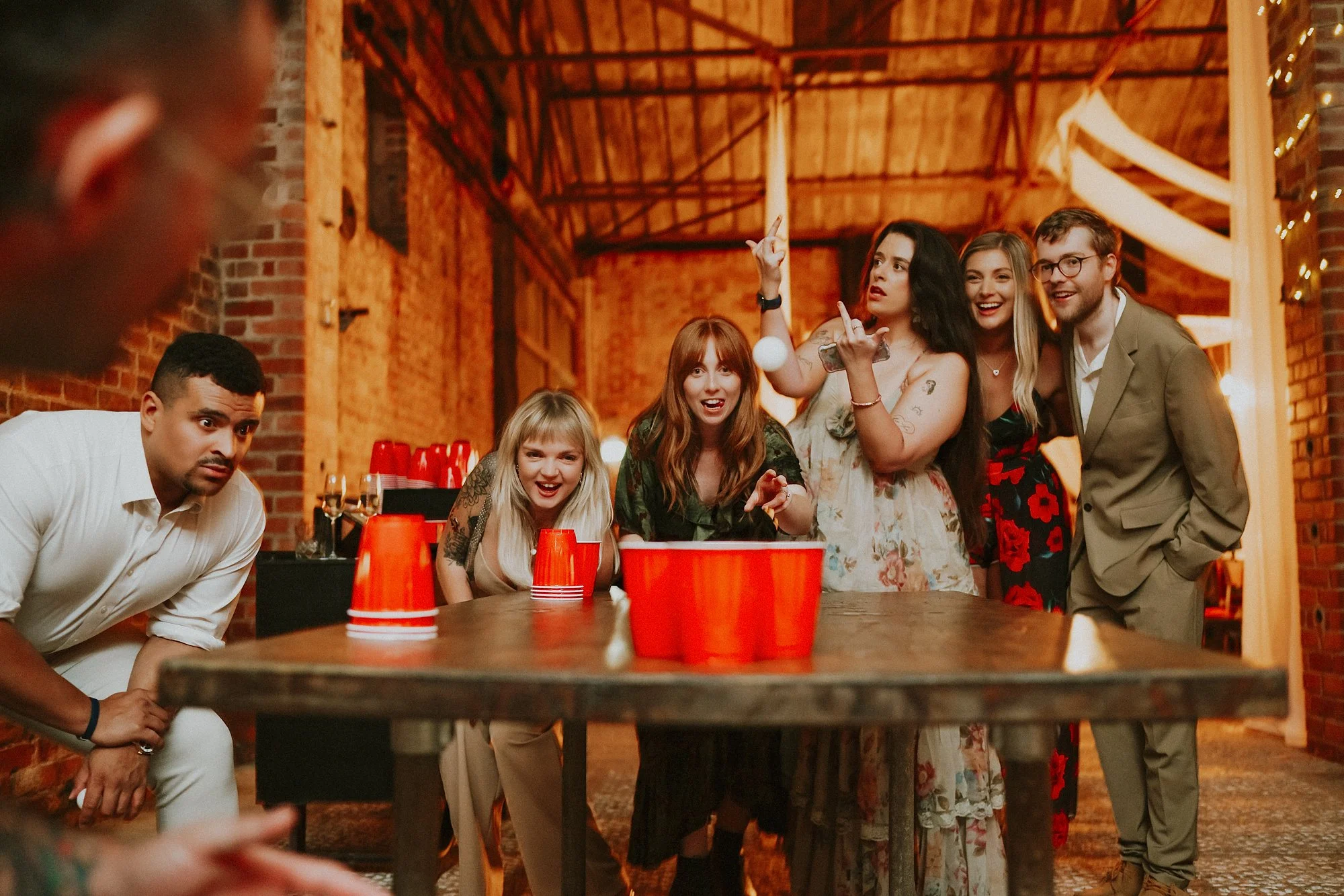 A candid photo of people playing beer pong during a White Syke Fields wedding reception.