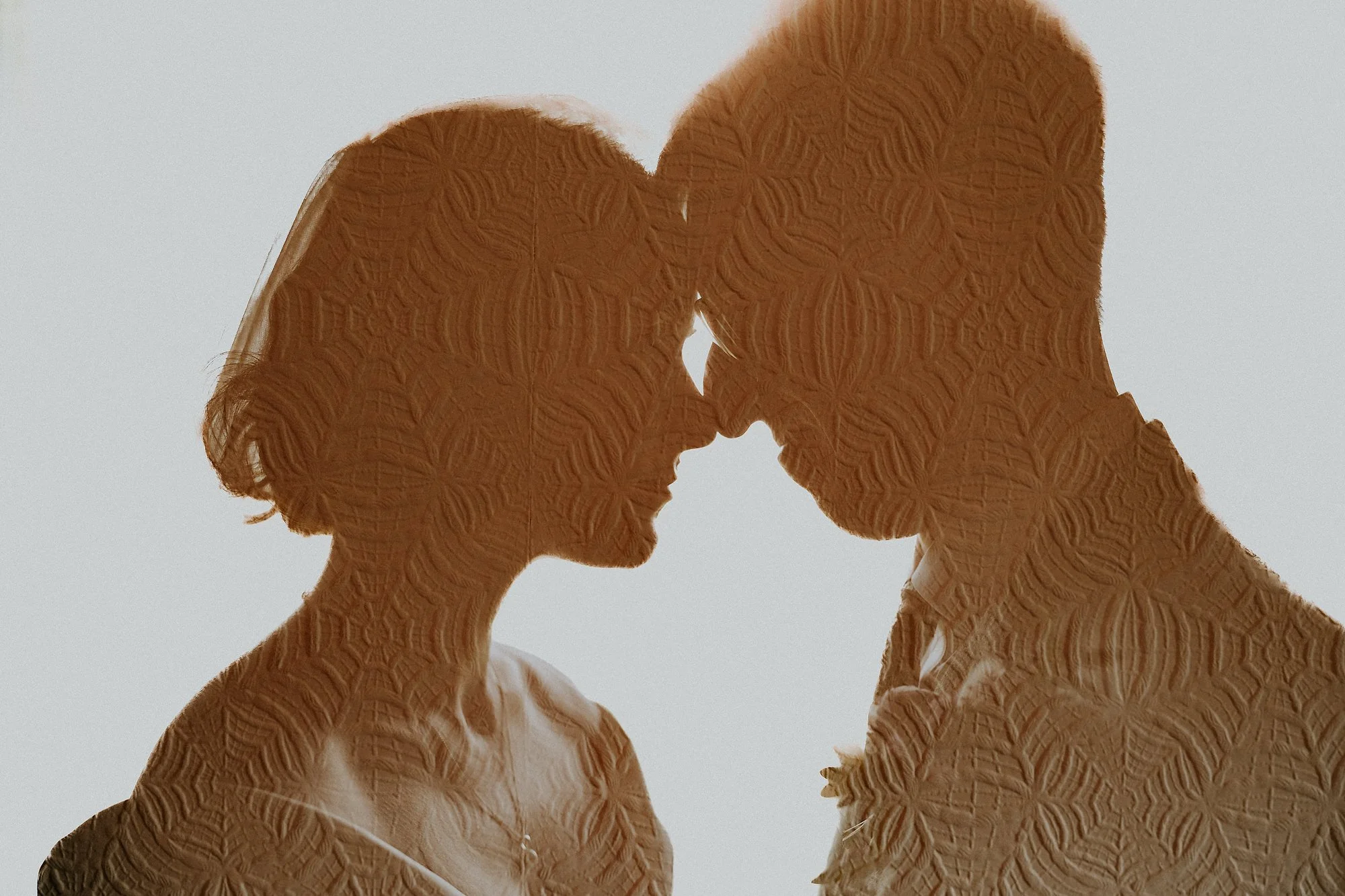 A double exposure of a Bride & Groom face to face with the elaborate wallpaper in their faces. Abstract beauty in this Wortley Hall wedding.