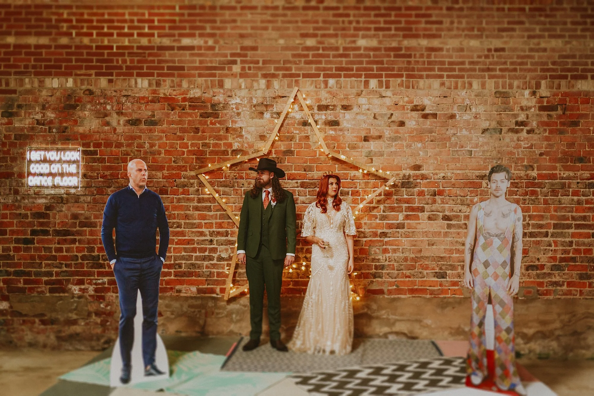 A funny wedding photo of a Bride and Groom with card board cut outs of Harry Styles and Arne Slot during their White Syke Fields wedding.