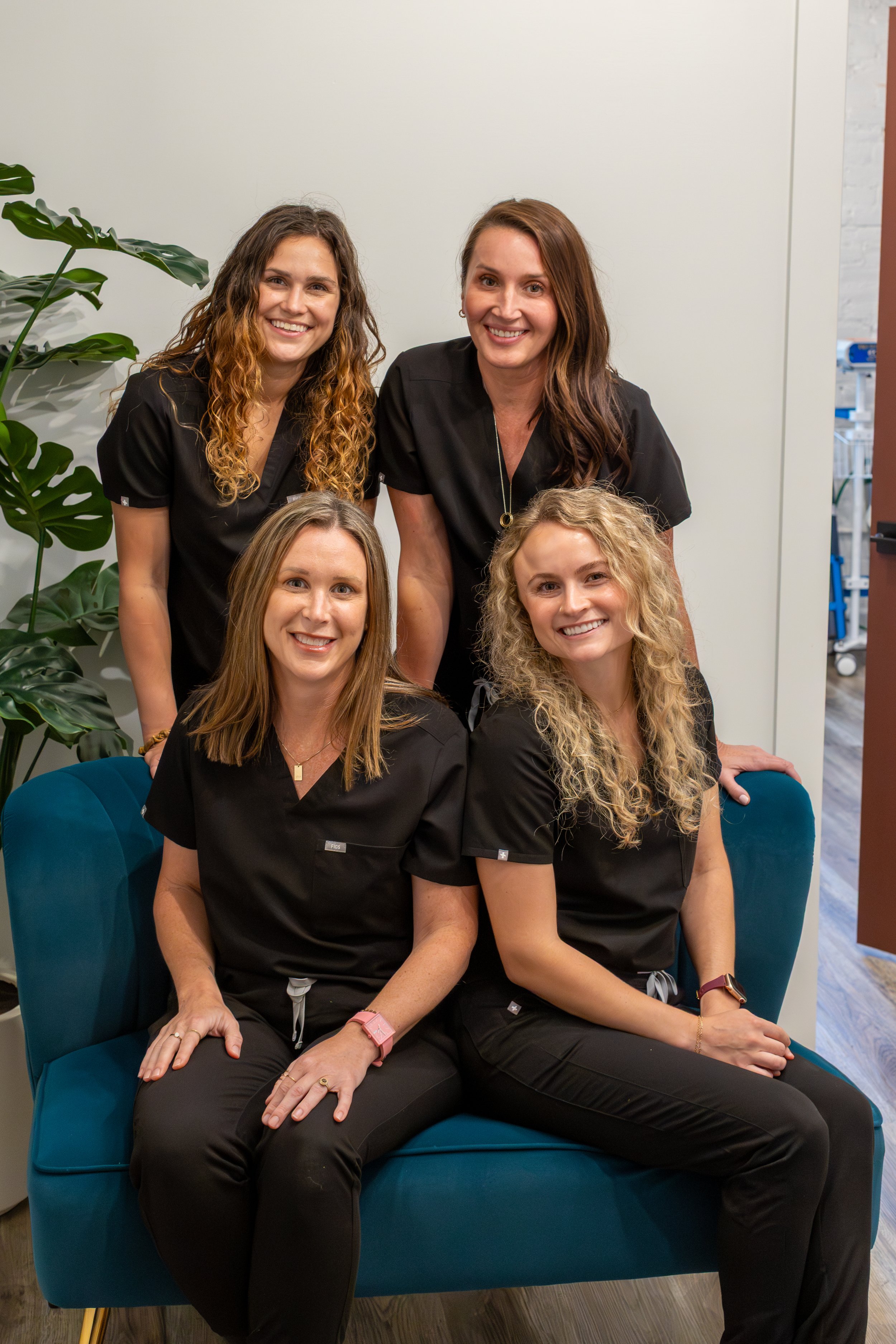 Dr. Janelle Maxwell, Marina Doctor, Abby Taylor are standing together in a room, smiling at the camera. They are wearing medical scrubs, indicating they might be healthcare workers or staff in a medical or professional setting.