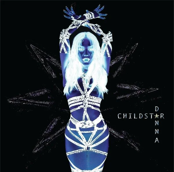 Main album cover visual for Danna's Childstar project photographed by Rafael Arroyo. The artwork presents a stylized, neon-blue negative image of the artist arranged symmetrically with arms positioned overhead, bounded by technical lines forming a di