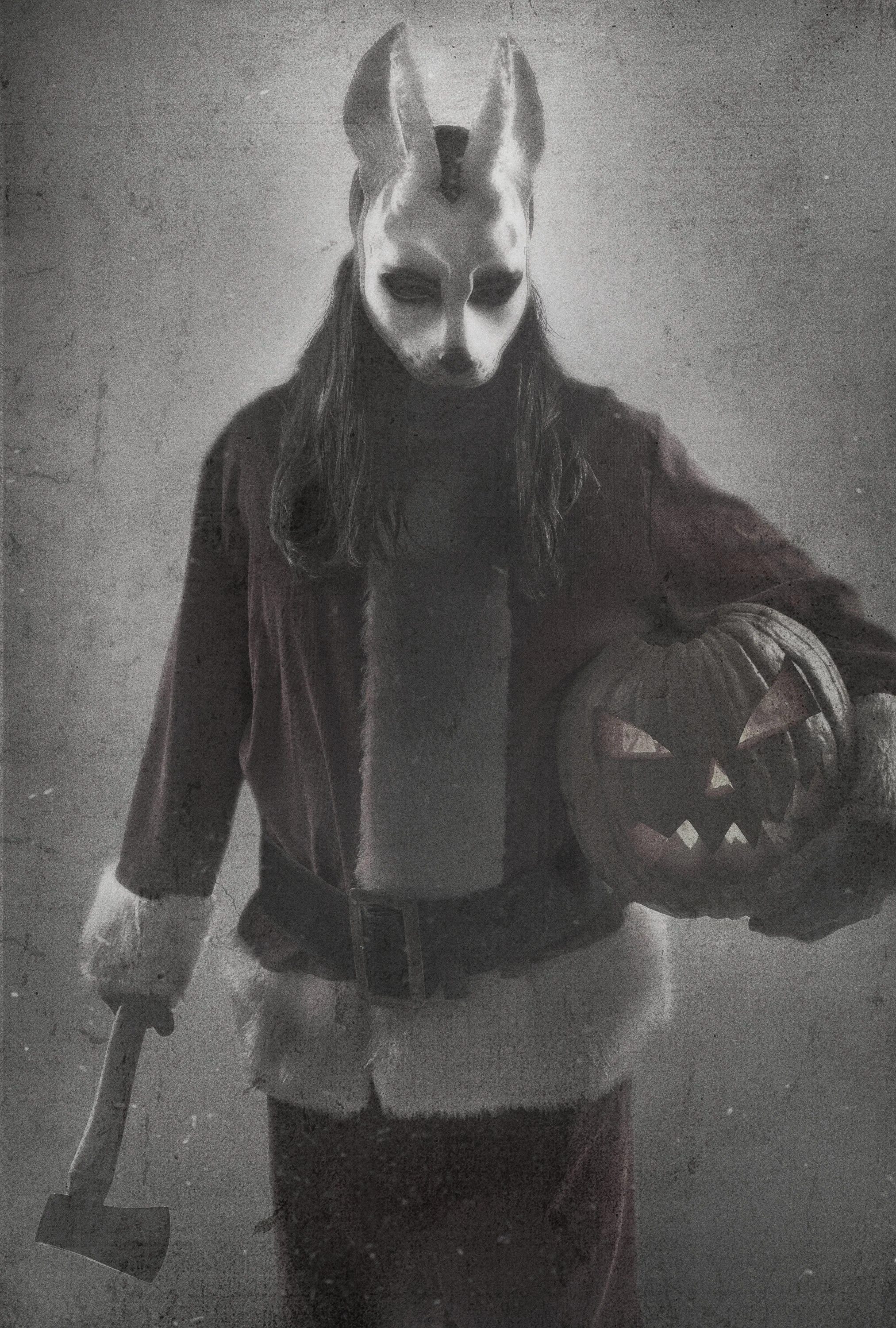 Person wearing a horror rabbit mask with a Santa suit while holding a pumpkin and axe, dressed in dark clothing, standing in a dimly lit setting. A body and wardrobe horror photo for a key art poster.