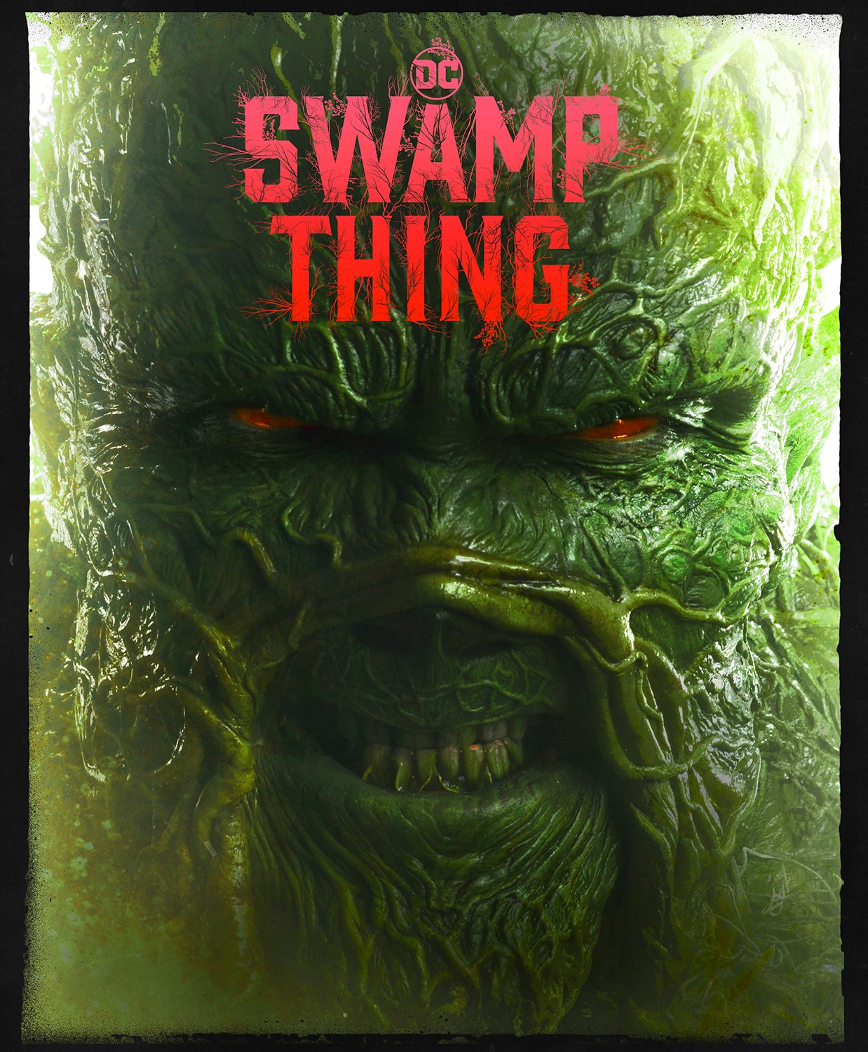 Close-up of a green, textured face resembling Swamp Thing, with glowing eyes and the title 'Swamp Thing' in red at the top.