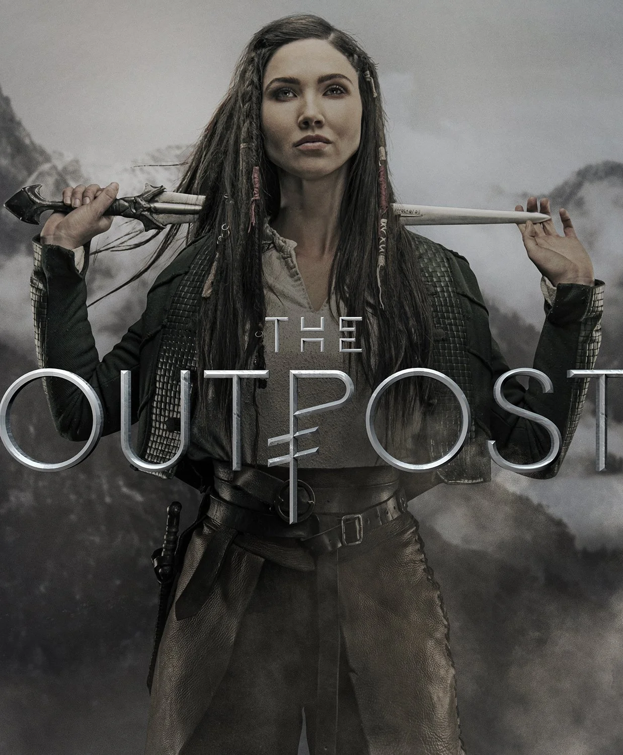 A woman with long dark hair, dressed in dark rugged clothing, holds a sword resting on her shoulders. The background is cloudy and mountainous, and the text 'THE OUTPOST' is overlaid on the image.