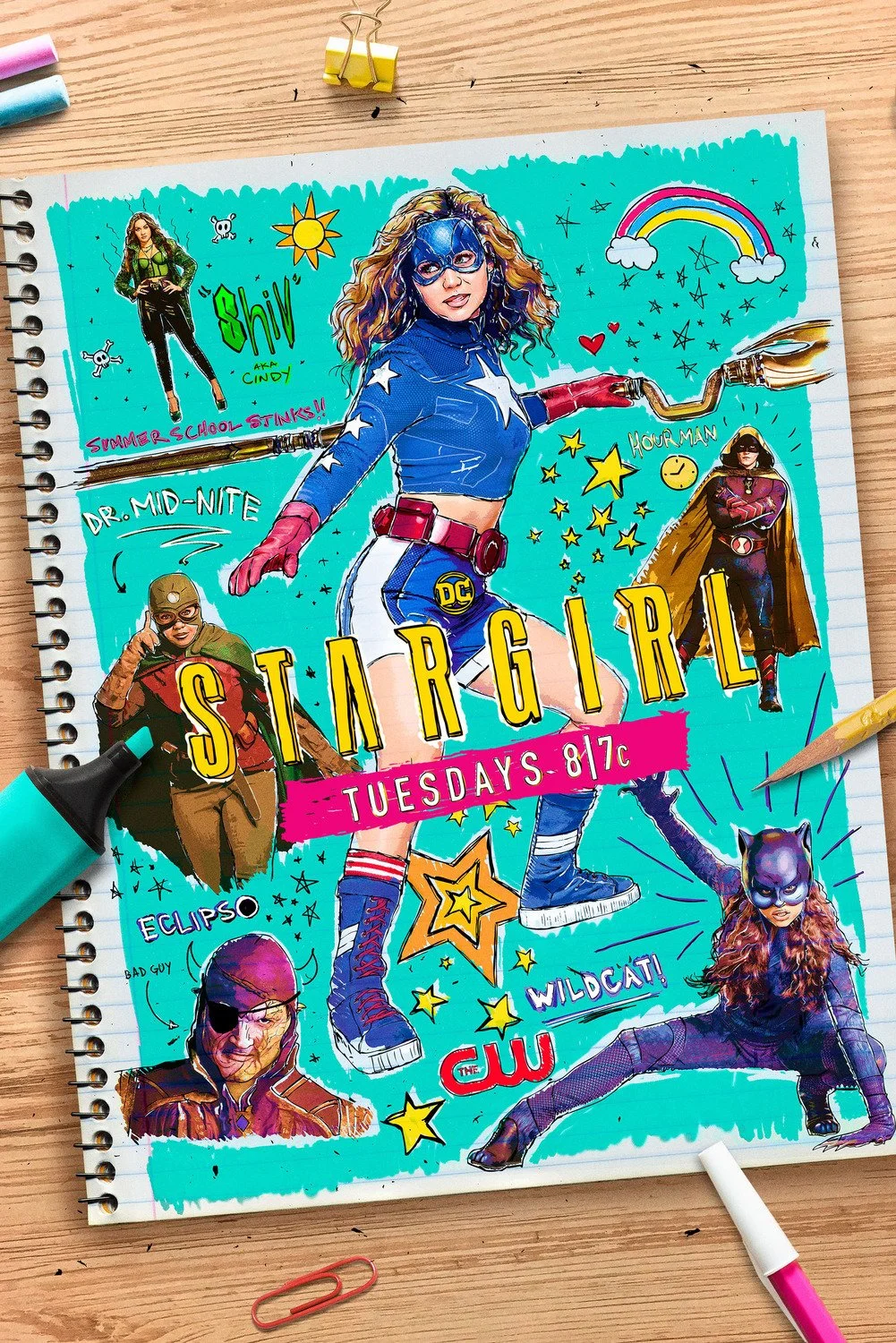 Colorful illustration of a female superhero with curly hair, wearing a blue costume with a star emblem, red gloves, and sneakers. Surrounding the main figure are smaller characters dressed as other superheroes, stars, rainbows, and doodles, with the 