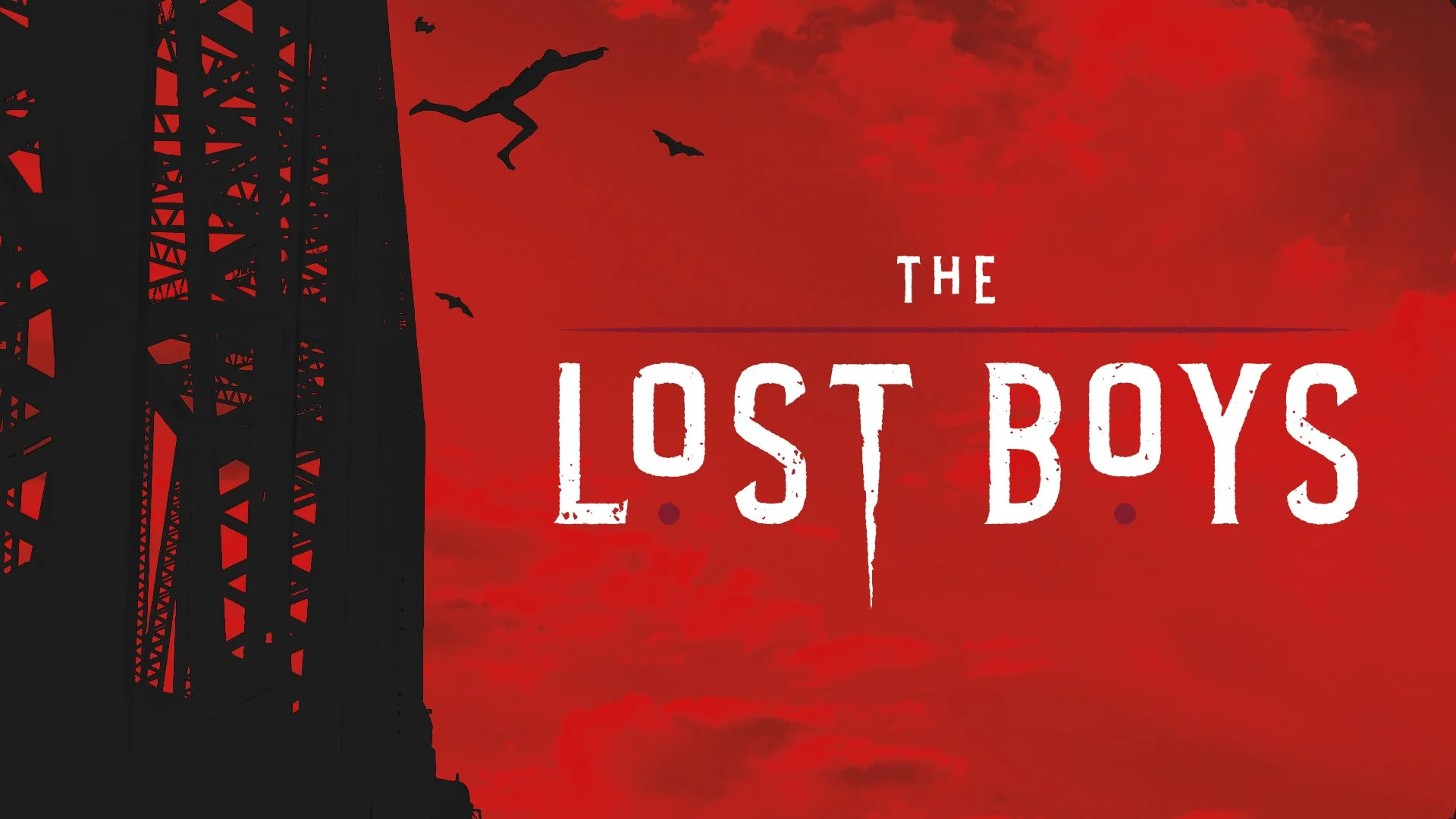Silhouette of a tall metal tower or antenna against a red-orange sky, with a few flying bats near the top, and the movie title 'The Lost Boys' in large, distressed white font in the center.