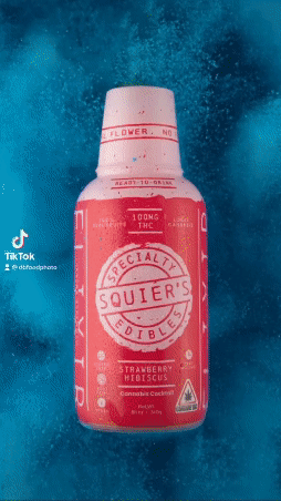 A bottle of Squier's Edibles Strawberry Hibiscus beverage containing 100mg THC against a blue swirling background.