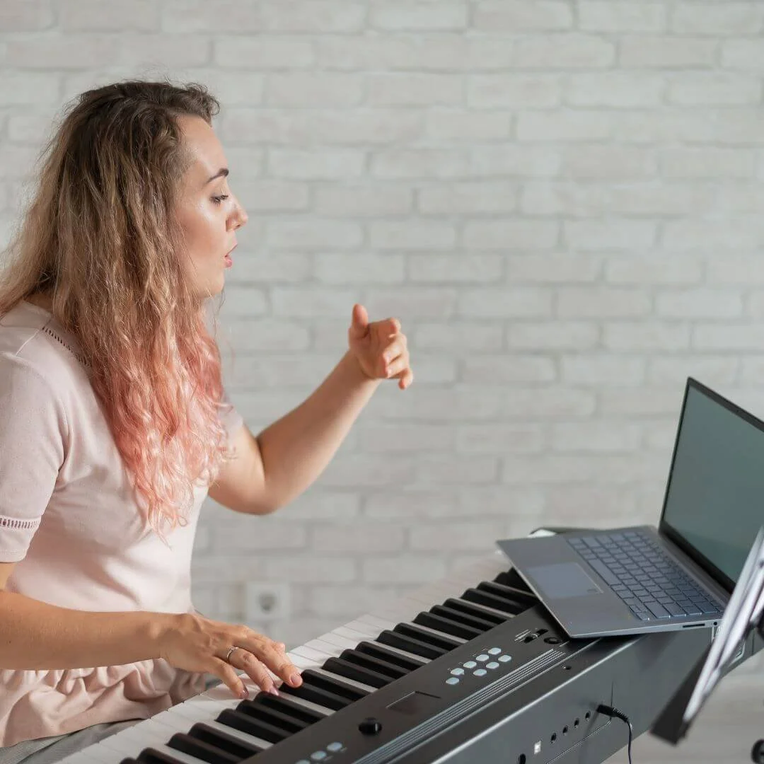 U2 Tuition online drama tutor delivering a virtual LAMDA Musical Theatre lesson on keyboard and laptop.