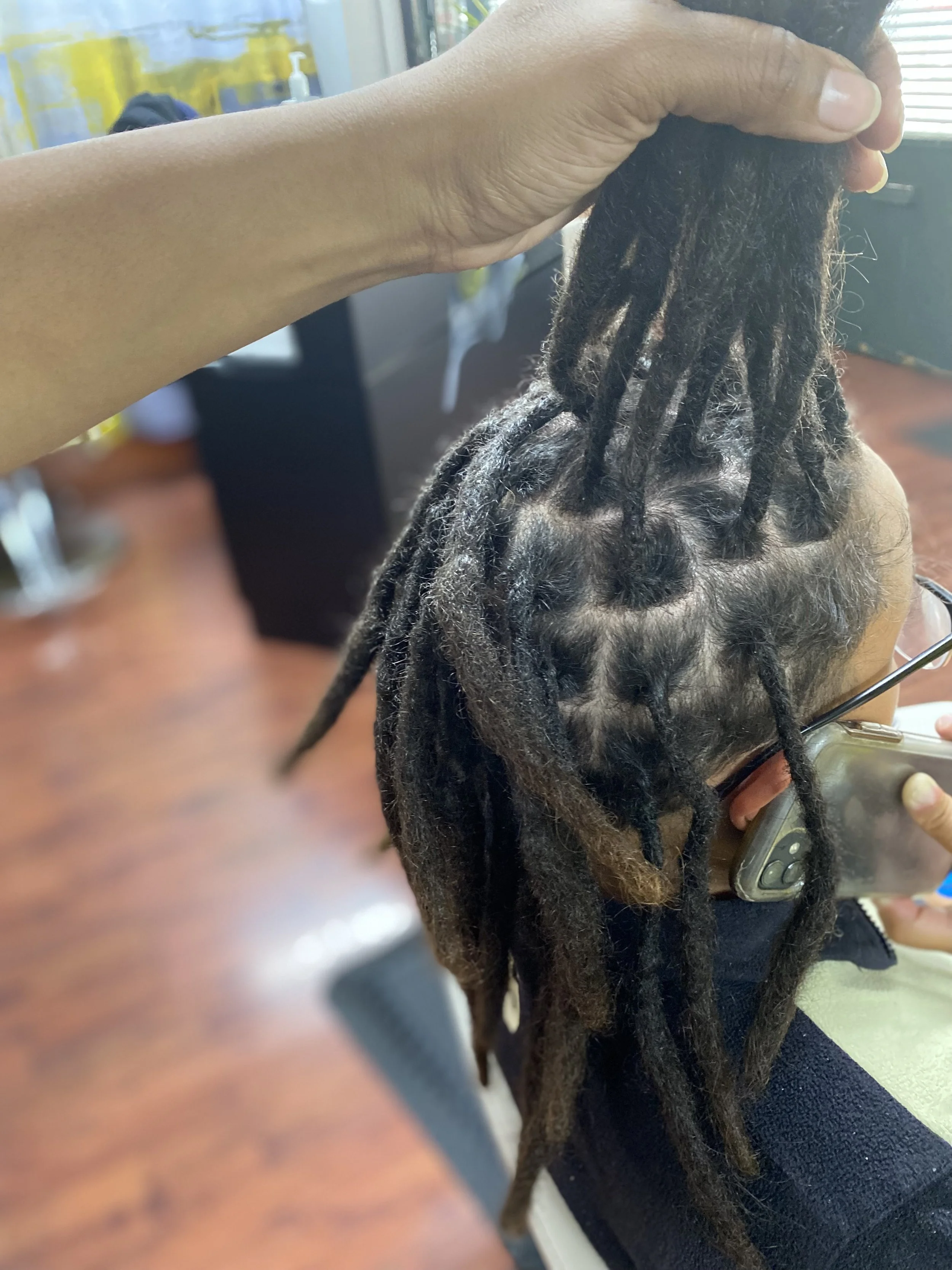 Person with Croche Locs having hair styled at a salon