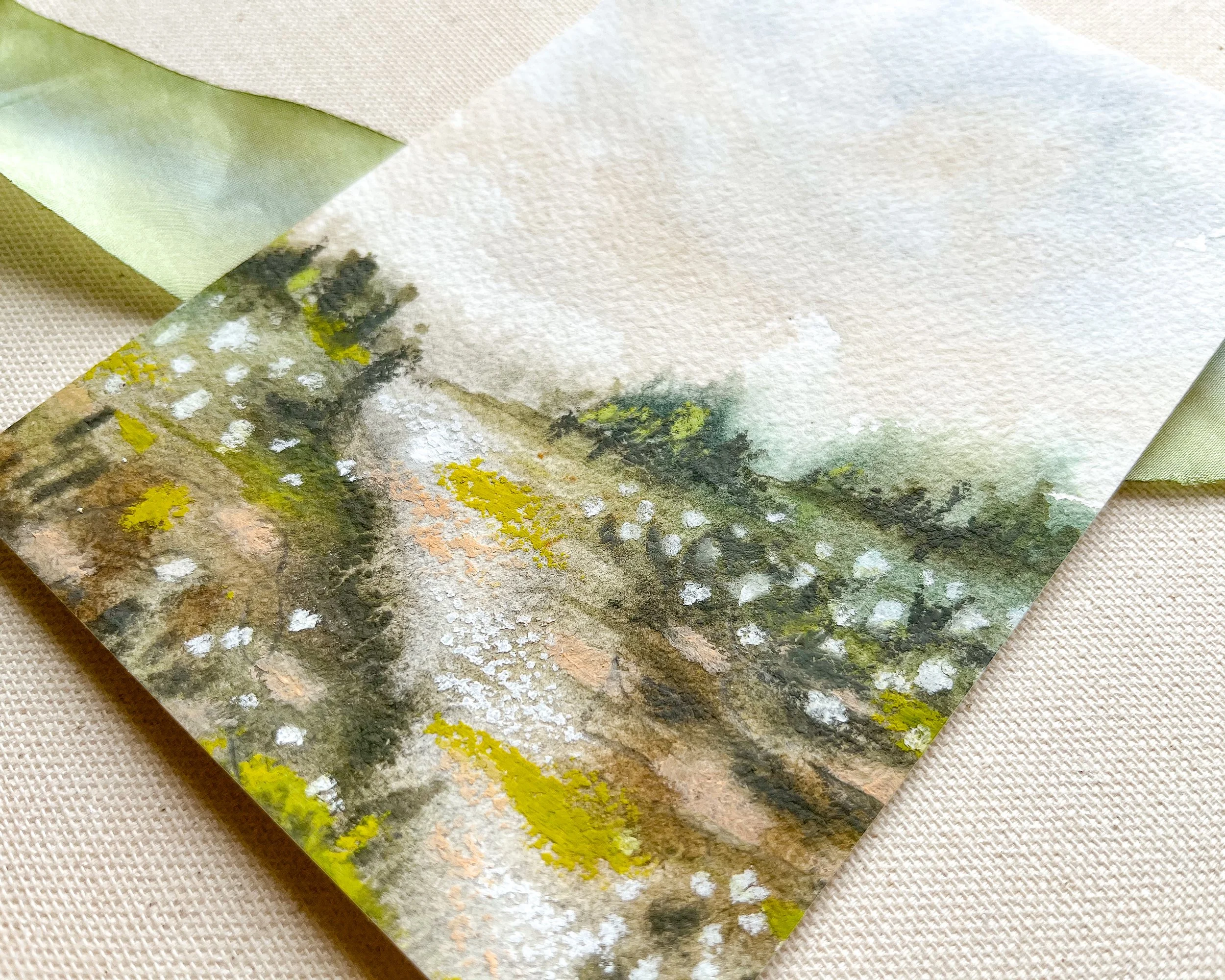 Close up view of expressive landscape painting in watercolor paint with pastel accents.