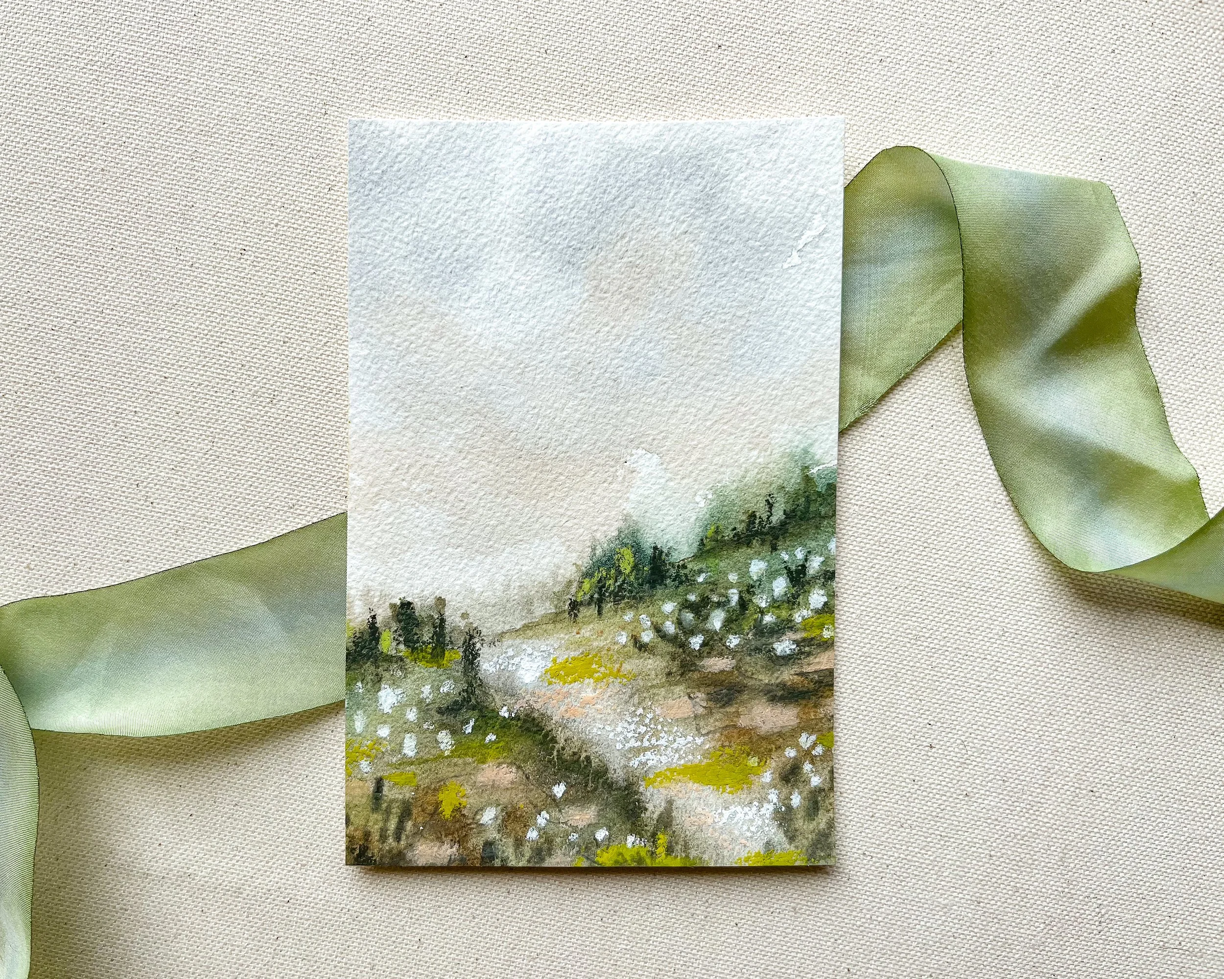 Original 4" x 6" mixed media landscape watercolor painting with pastel accents. Actual painting is photographed atop a green silk ribbon.