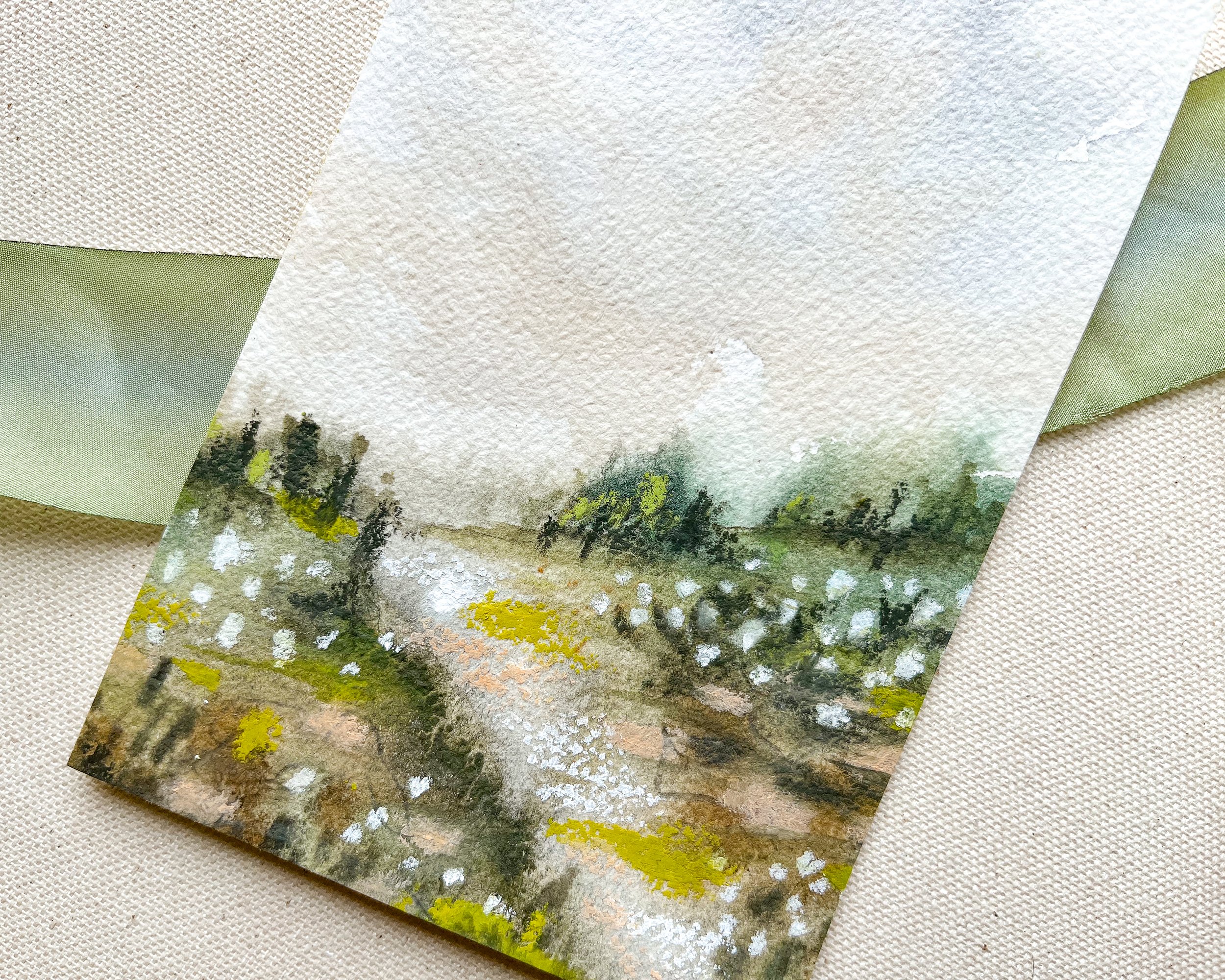 Top view of mixed media landscape painting in watercolor paint with pastel accents.
