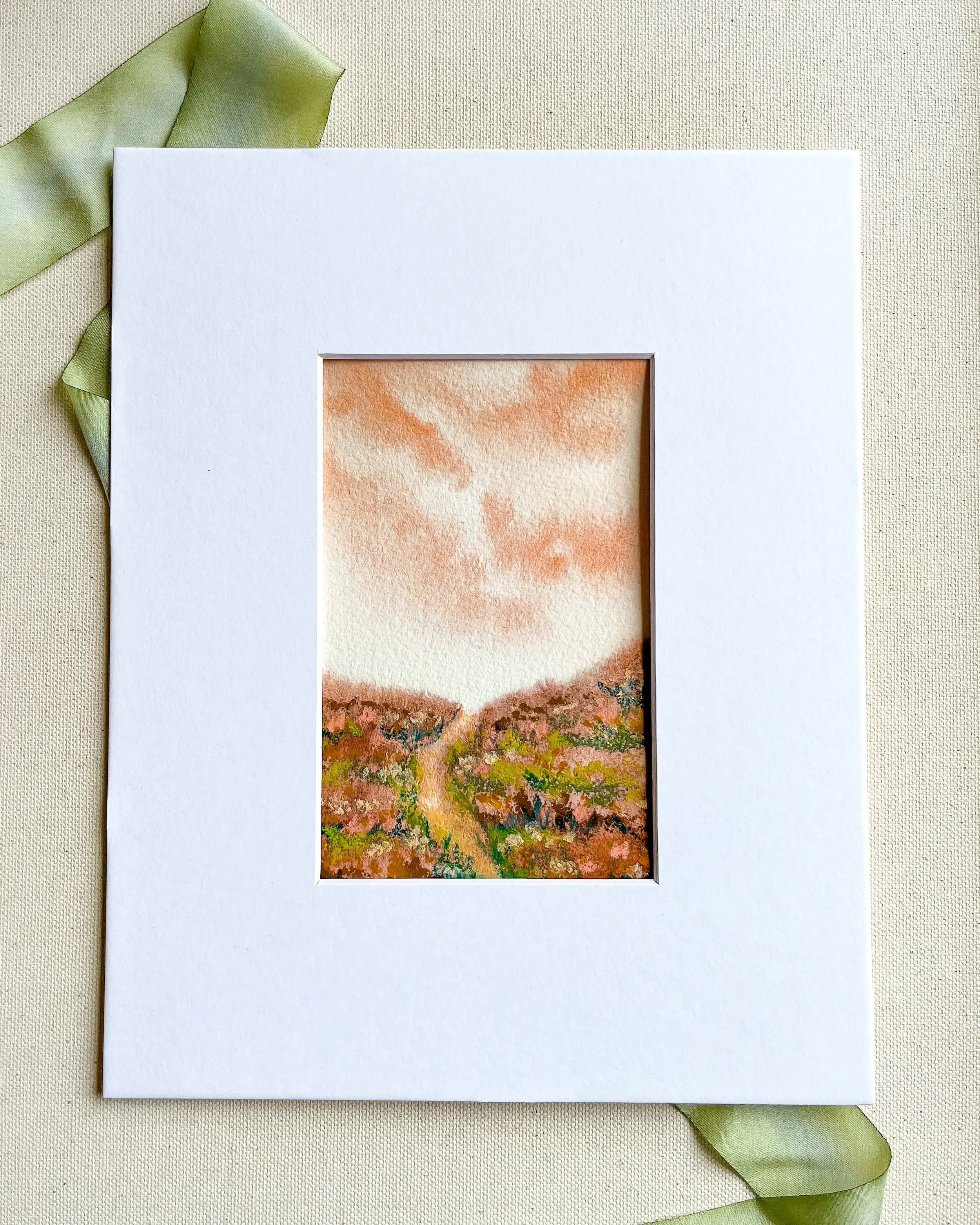 Mixed media landscape in pink pastels shown under optional white mat. Mat measures 8" x 10" with an opening just under 4" x 6"