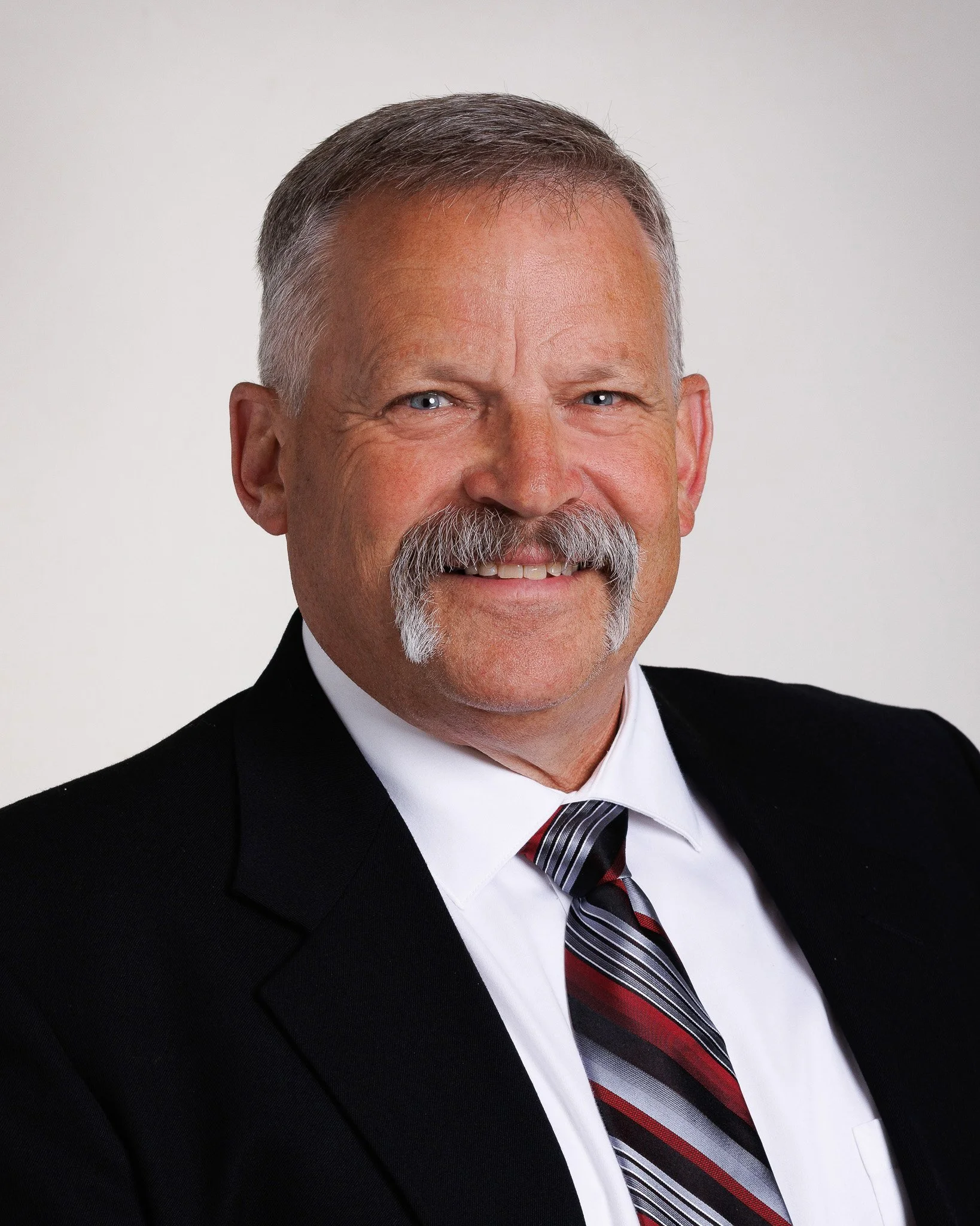 Business headshot for a real estate agent featuring confident posing and professional lighting.