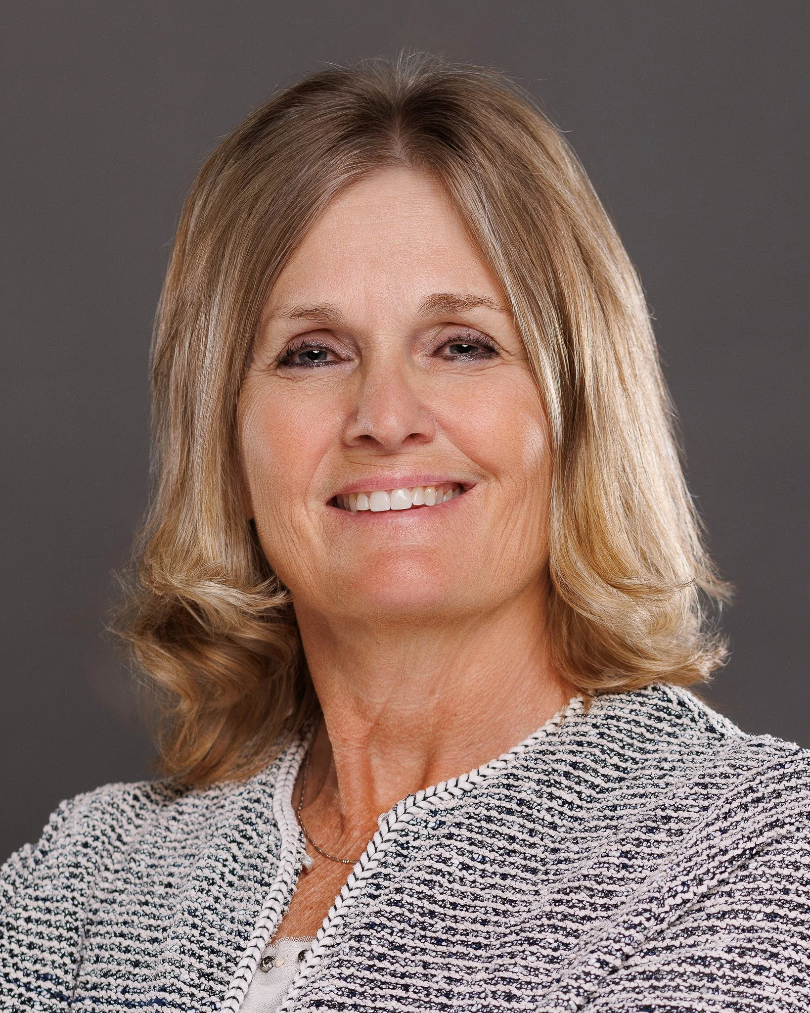Corporate professional headshot of a female doctor with expert retouching and neutral background.