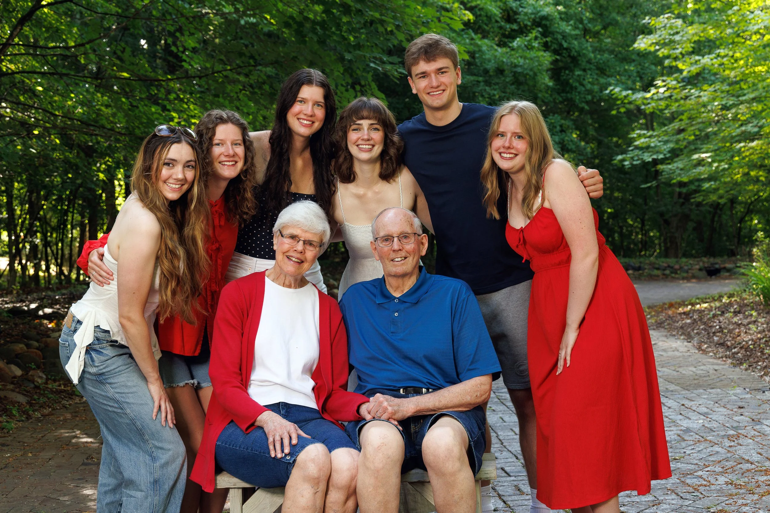 A multi-generational family portrait outdoors in a wooded area for a photo, with children, adults in Rice Lake, Wi area.