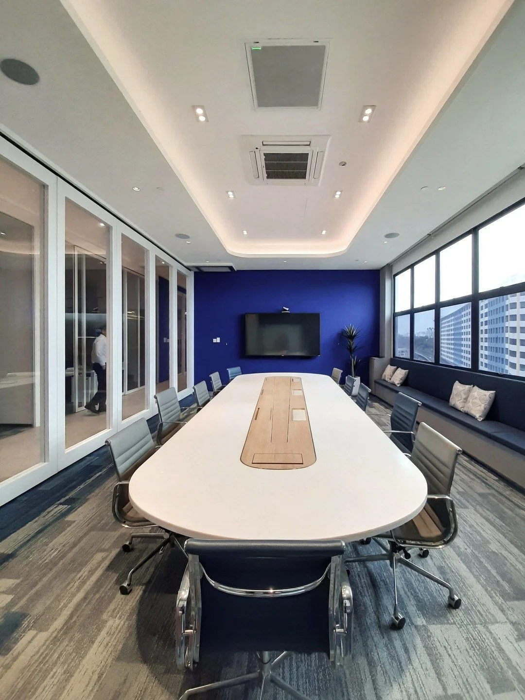 The Boardroom of Biomed Global's office displays the regional company's distinct identity, with the focal point on the bold blue backdrop of the presentation screen. This is echoed in the furnishing and finishes, coupled with the organic form of the 