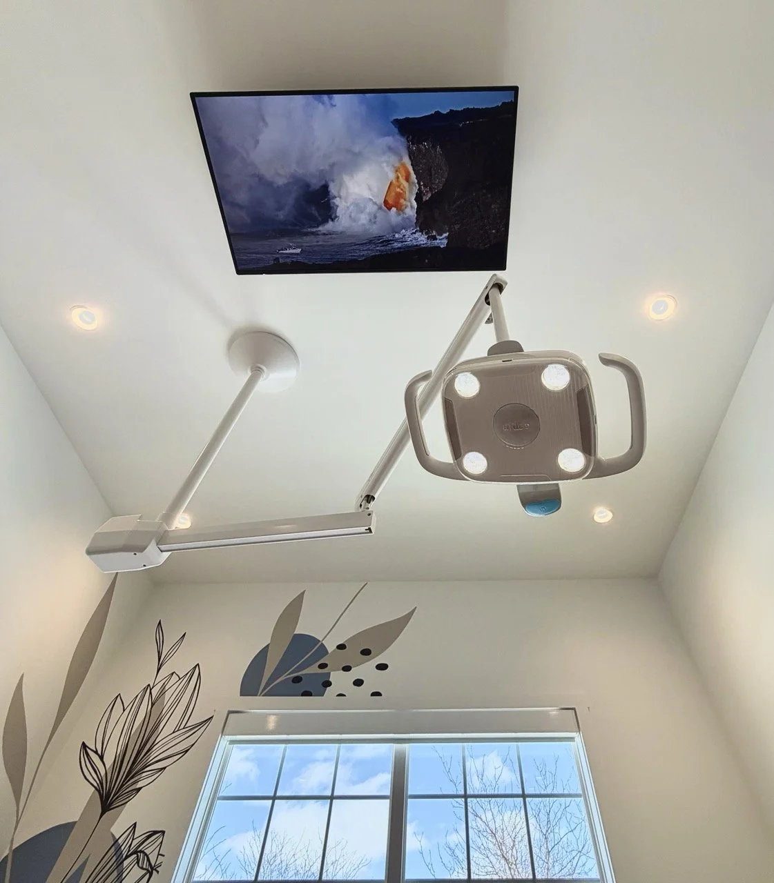 television mounted on the ceiling above dental chair