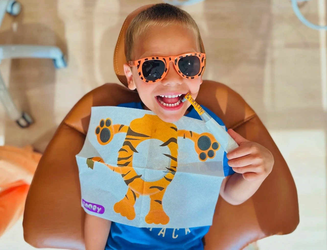 kid smiling with animal prophy angle and bib