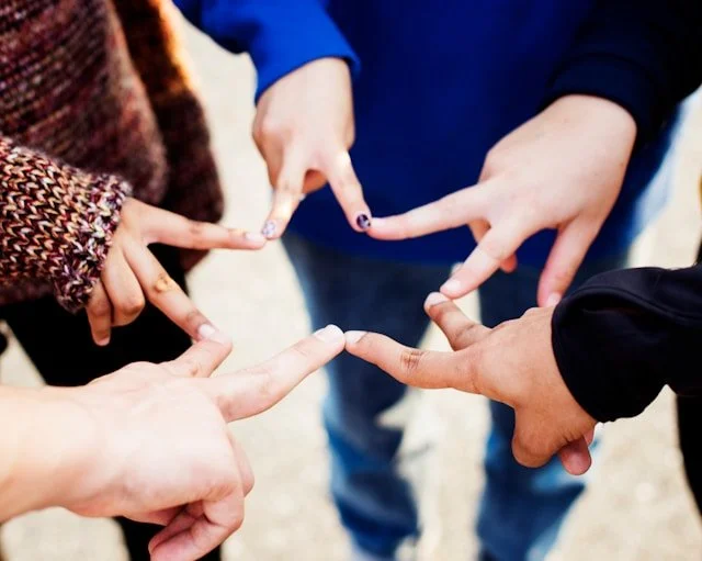 a group of hands making a star patterns with their fingertips