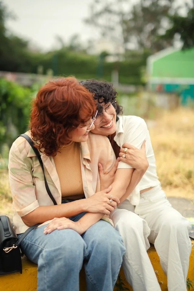 queer couple embracing and smiling