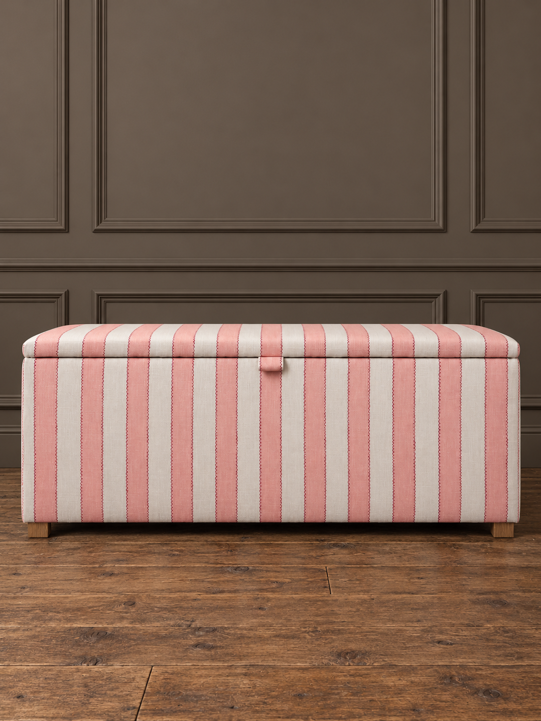 Pink-striped ottoman on rustic wood.png