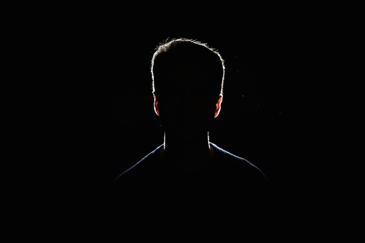 silhouette of man with black background representing the human self and theology