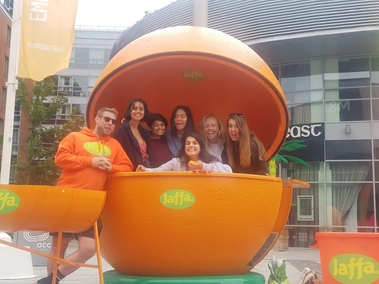 Inglis Netball Club players posing inside a giant orange at the 2019 Netball World Cup