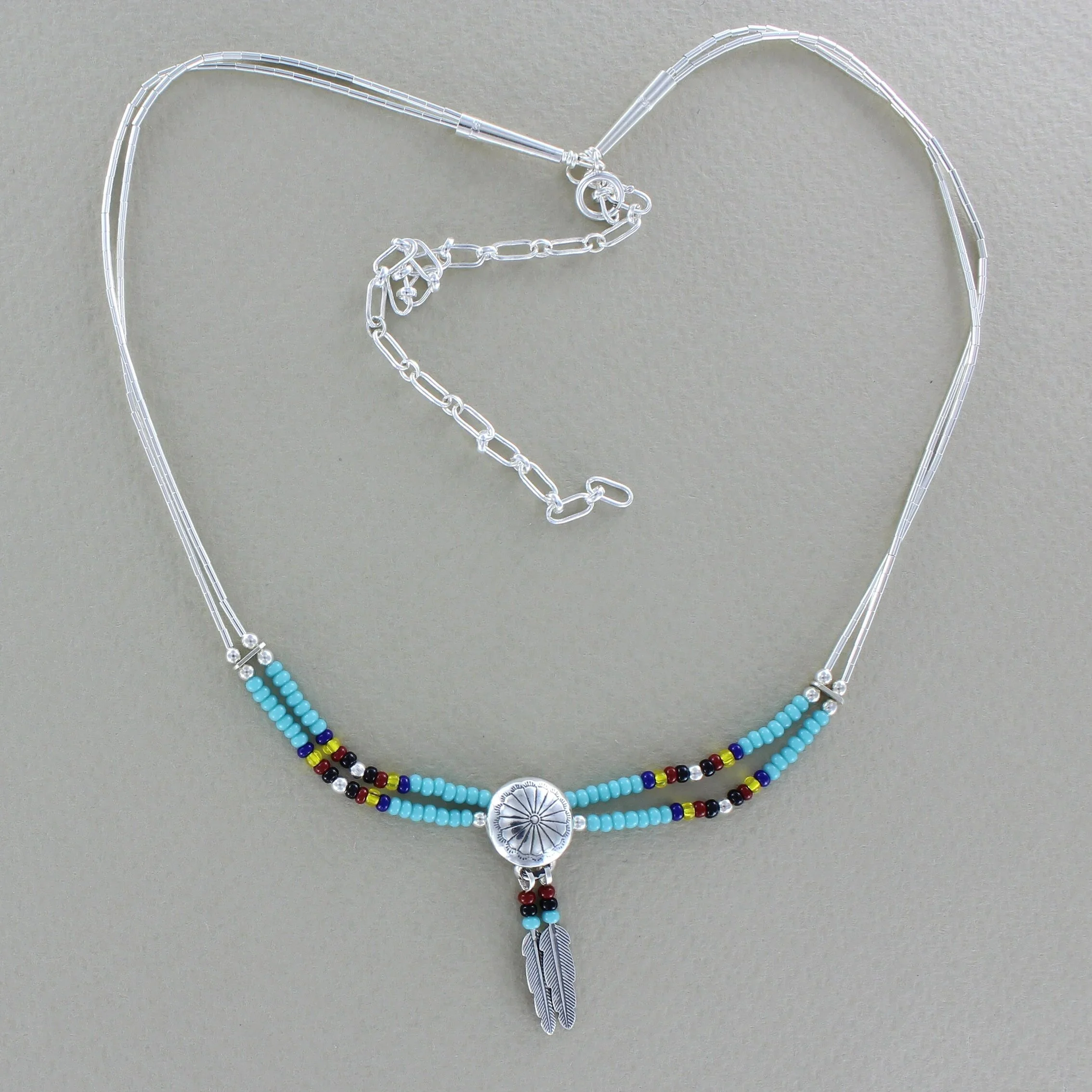 2 strand necklace with seadbead, central silver conch and two feathers
