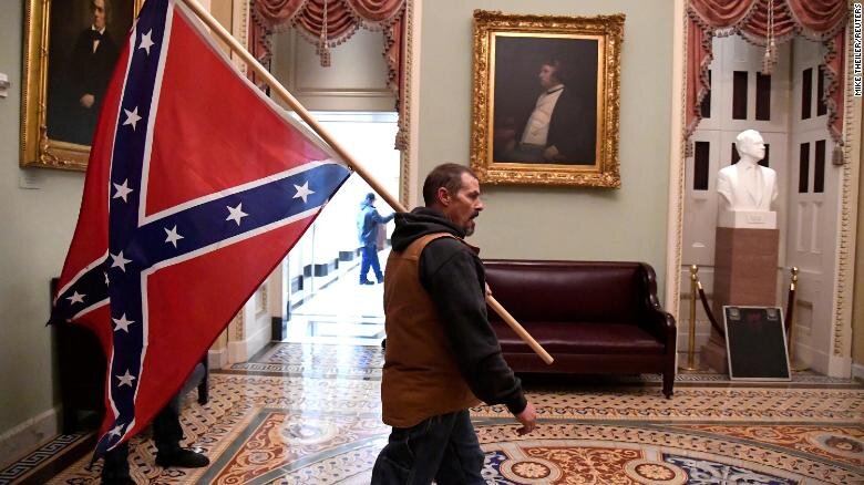 A Pro-Trump rioter carries a Confederate flag near the U.S. Capitol Rotunda January 6, 2021, in Washington, D.C. Saul Loeb, AFP via Getty Images.