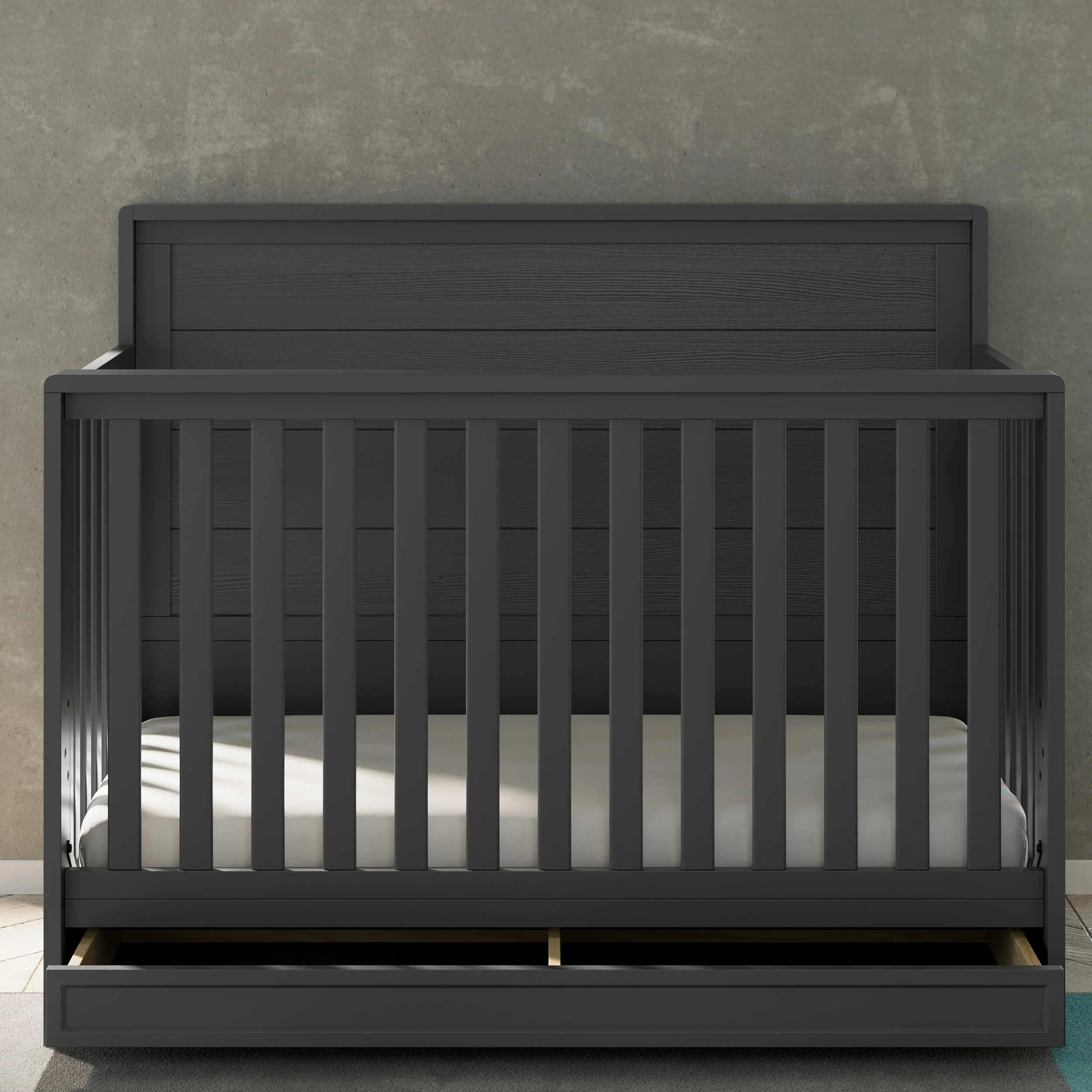 Gray crib with open drawer in nursery