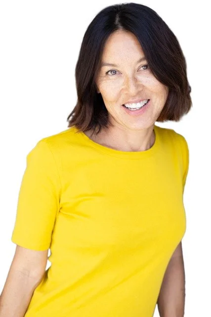 Woman smiling, wearing a yellow shirt, with shoulder-length dark hair against a white background.
