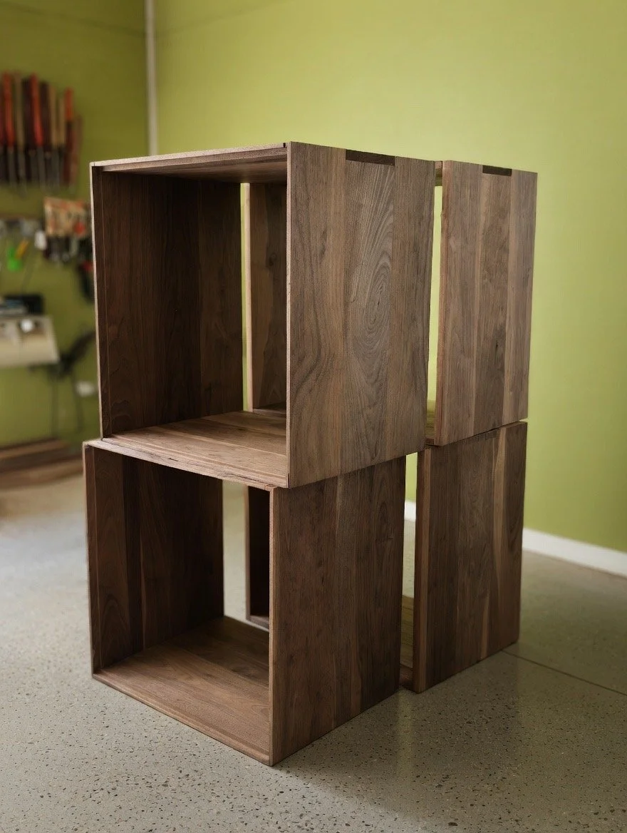 Stacked wooden storage cubes on a speckled gray floor in front of a green wall.