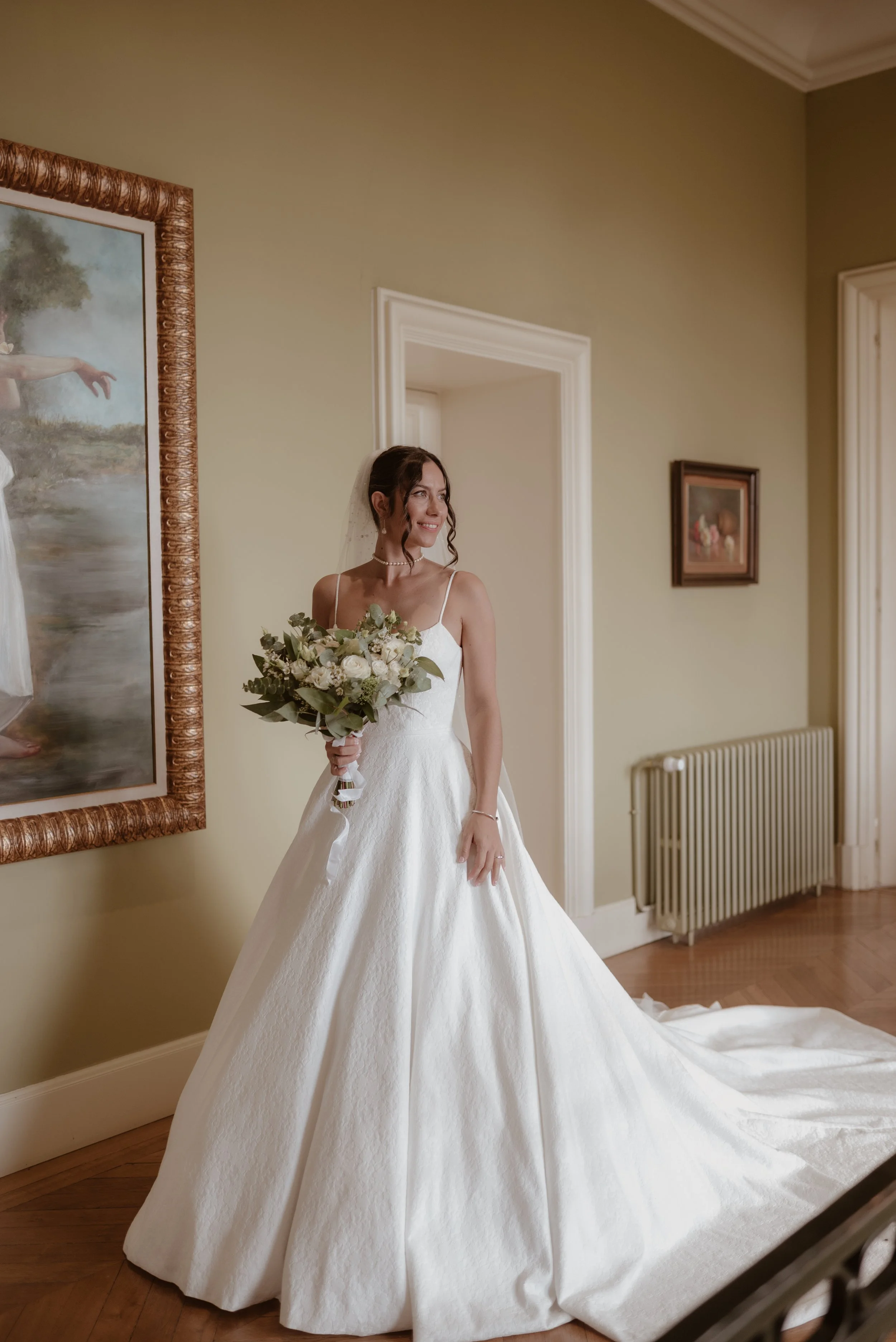 Femme en robe de mariée avec bouquet dans une pièce élégante