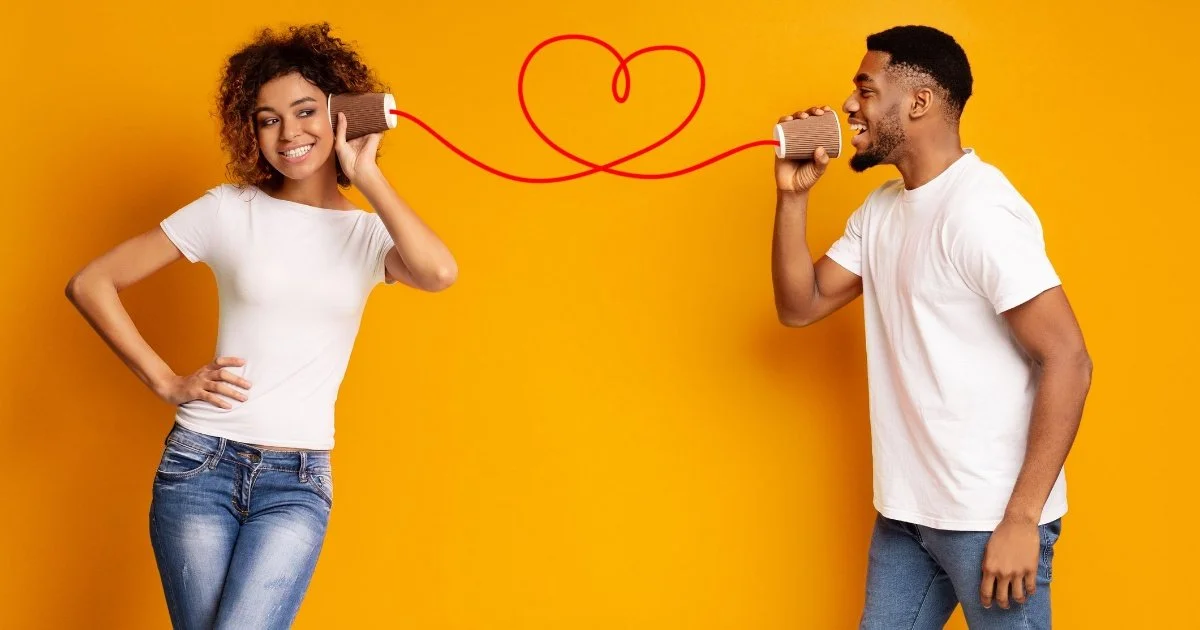couple holding cups to their ears talking and smiling