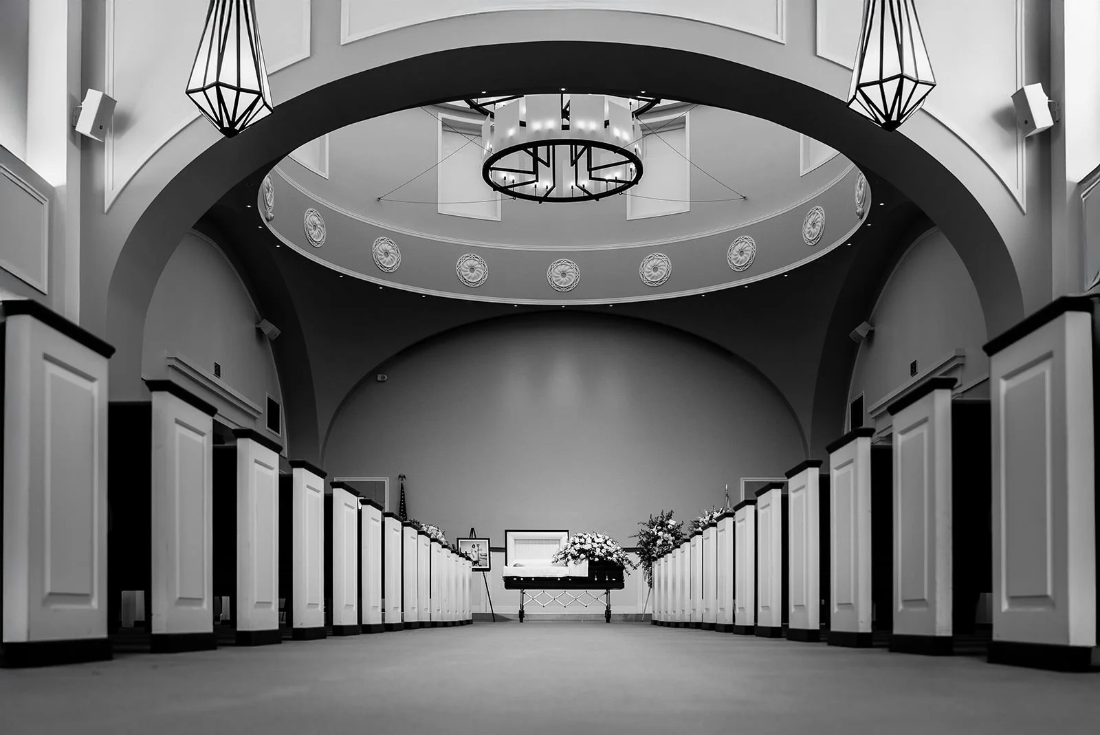 Funeral service chapel with open casket and floral arrangements at Forest Lawn Cypress