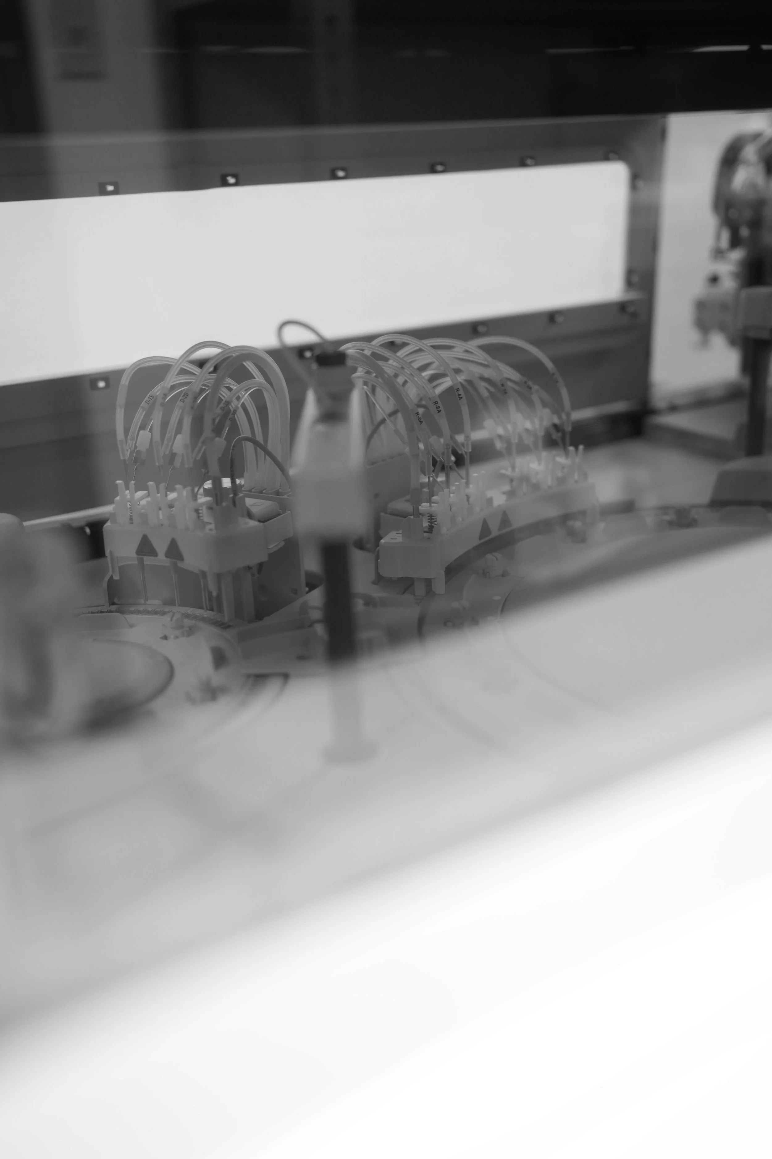 Laboratory equipment with tubes and containers behind a glass window.