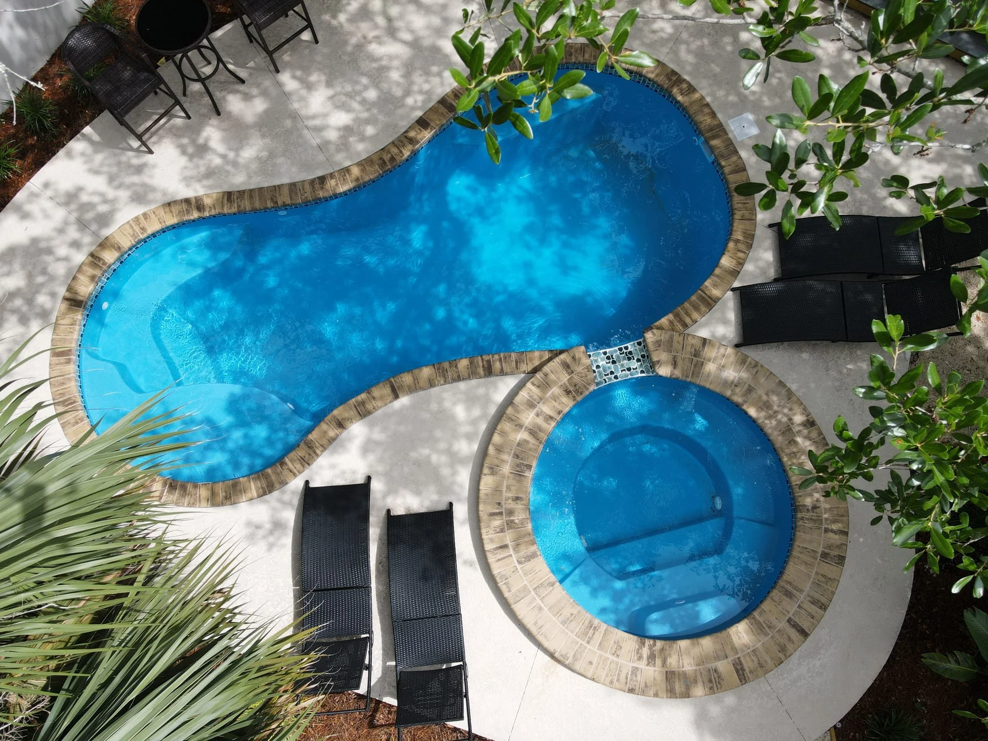 Custom pool retreat with water features and tropical backyard design