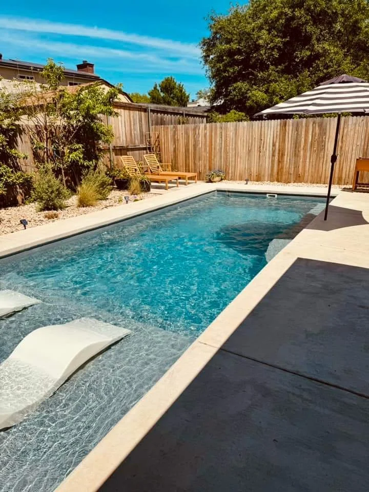 Family backyard pool installation with patio and outdoor living space